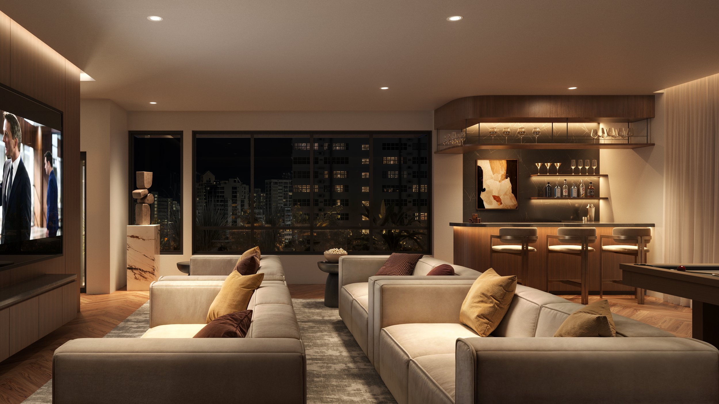Modern living room with beige sofas, throw pillows, a large window showing nighttime cityscape, and a bar area with glasses and bottles.