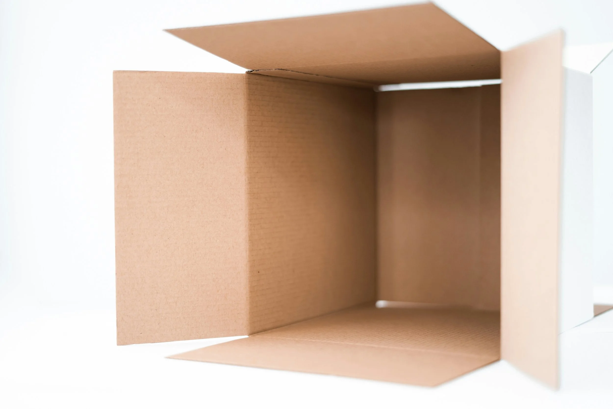 An empty, open, brown cardboard box viewed from the top showing the interior.