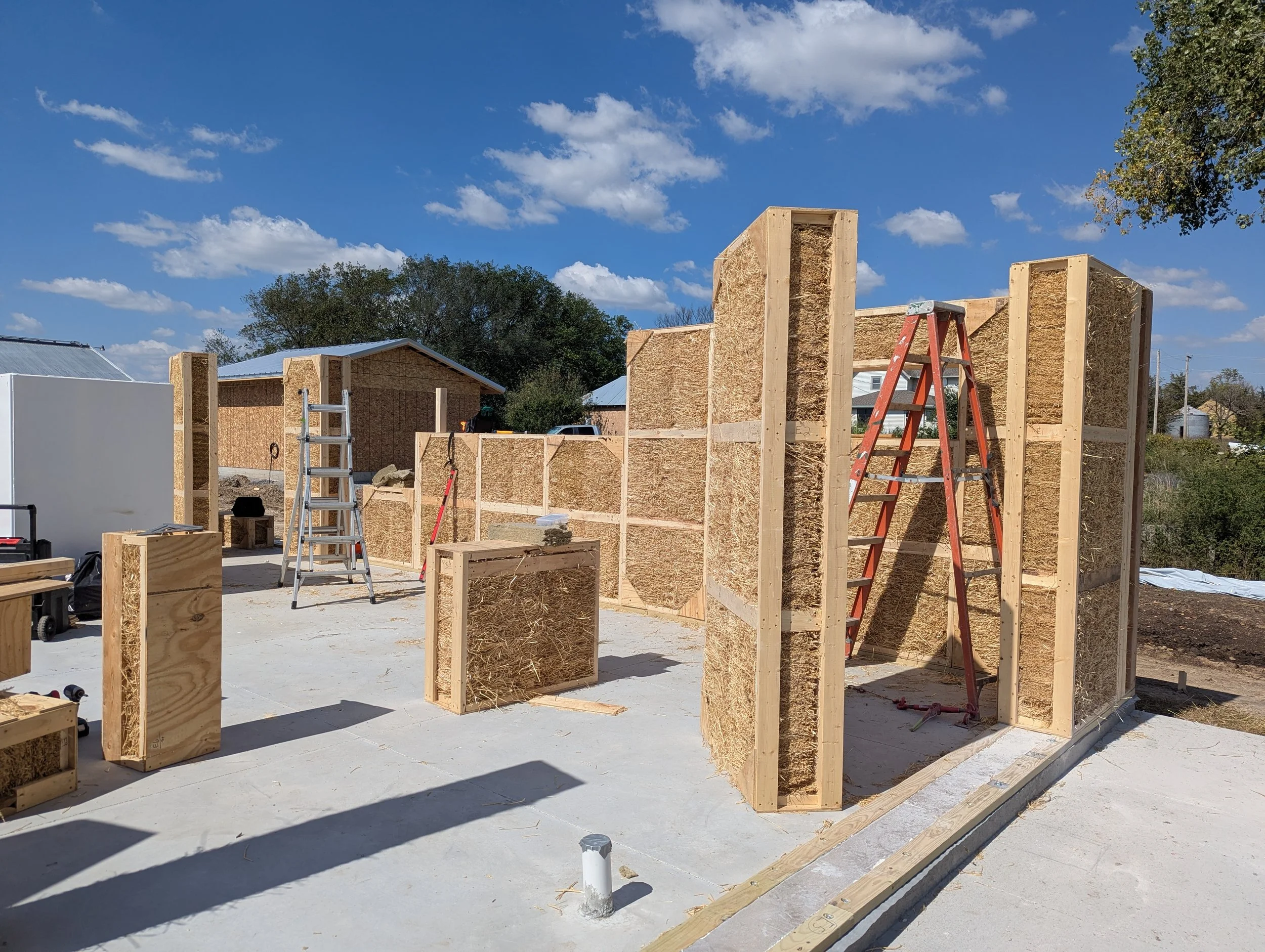 Building Integrity prefabricated straw wall panels installed and standing upright on an active construction job site