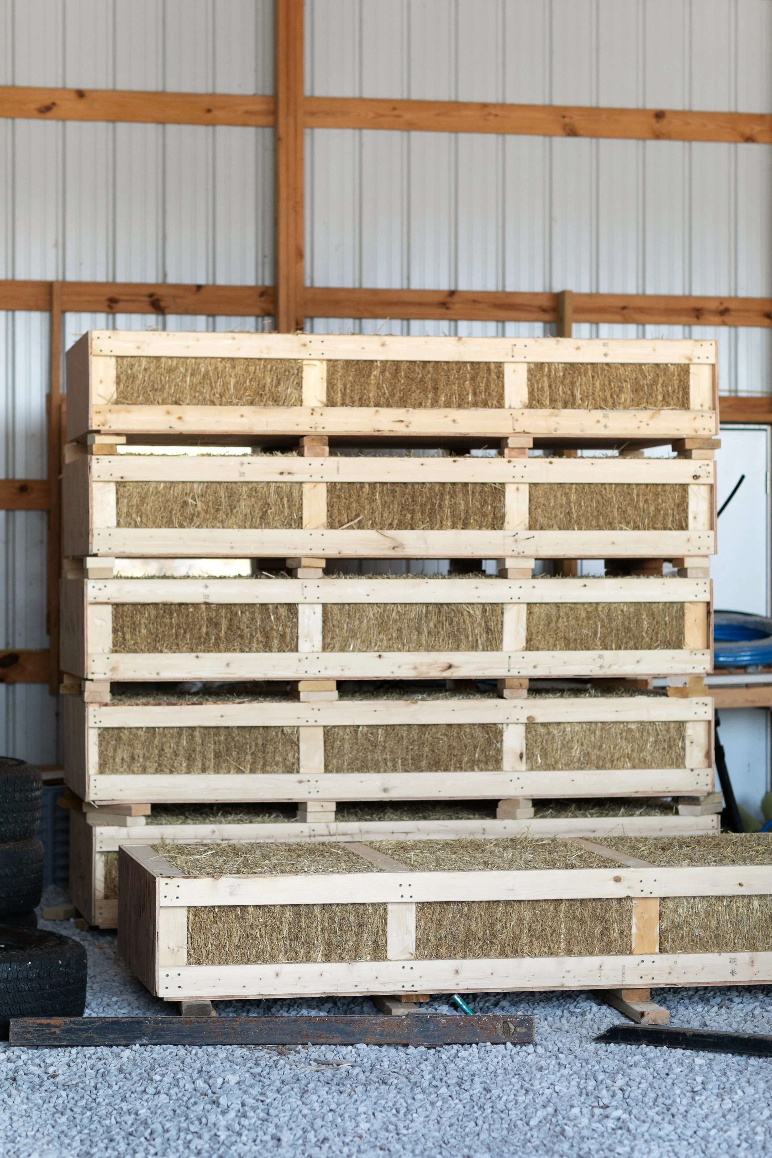 Completed prefabricated straw wall panels staged in Building Integrity's fabrication shop awaiting delivery to construction site