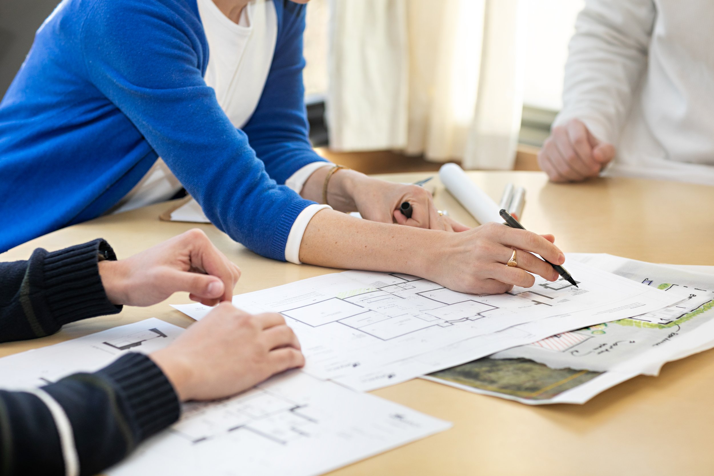 Adrienne, architect-owner of Monarch Architecture and Building Integrity cofounder, marking up custom straw panel plans for a client project