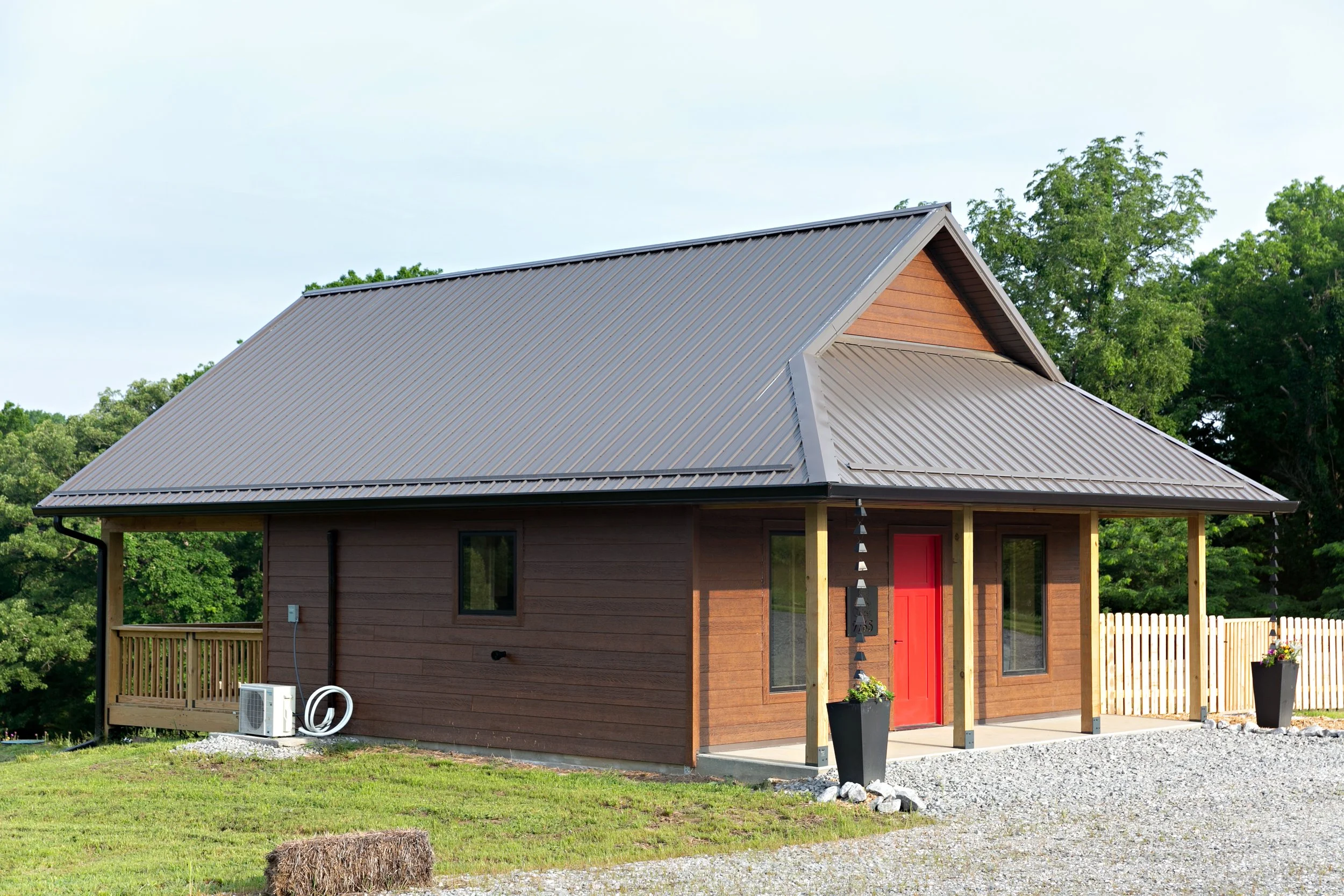 Building Integrity's The Joan panel ready plan exterior rendering showcasing the steep roof loft design and natural building aesthetic of a prefabricated straw panel studio home