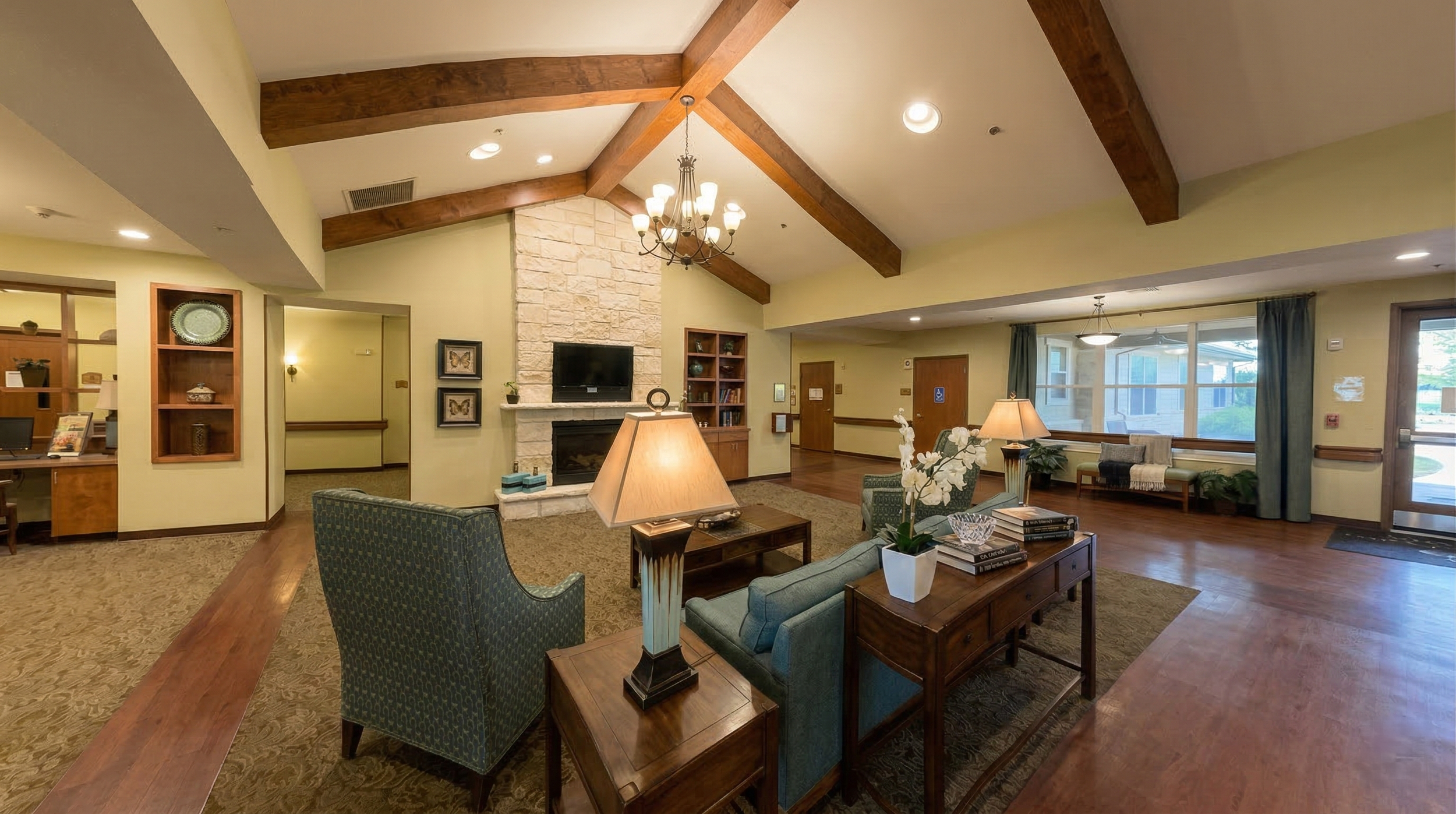 Luxury lobby area with seating, wooden accents, fireplace, and large windows for family visitation.