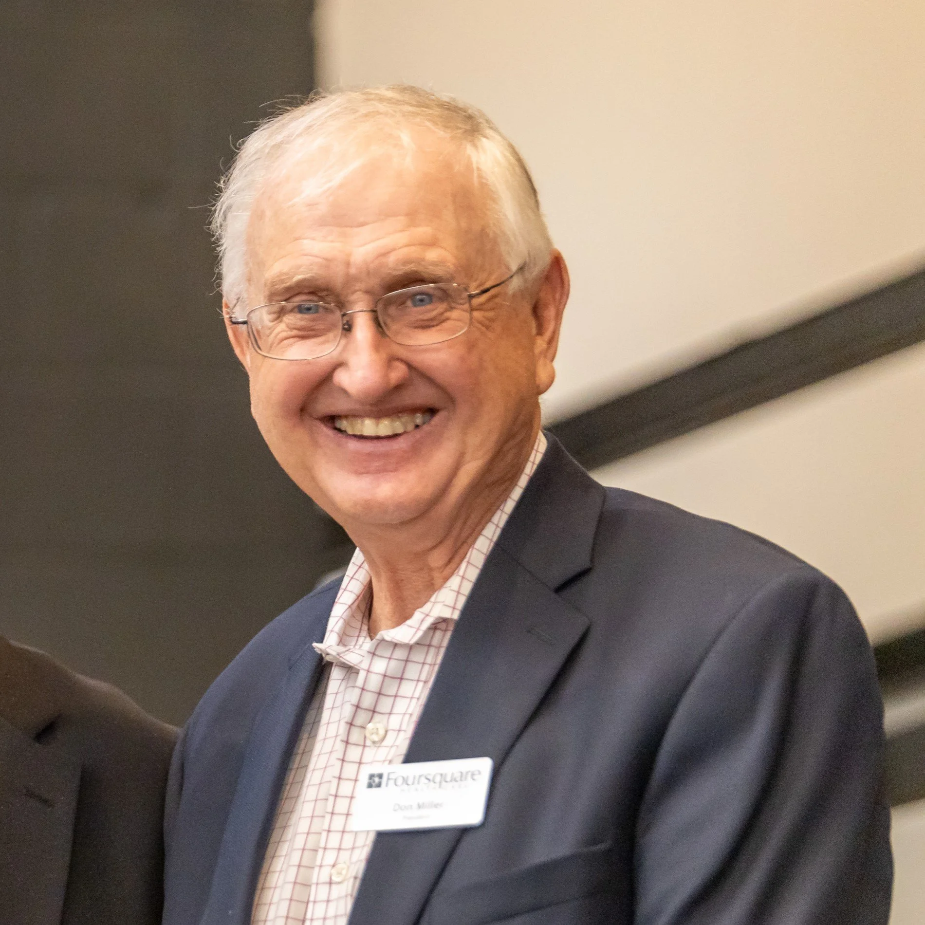 Don Miller dressed in a suit and shirt, at a professional event.