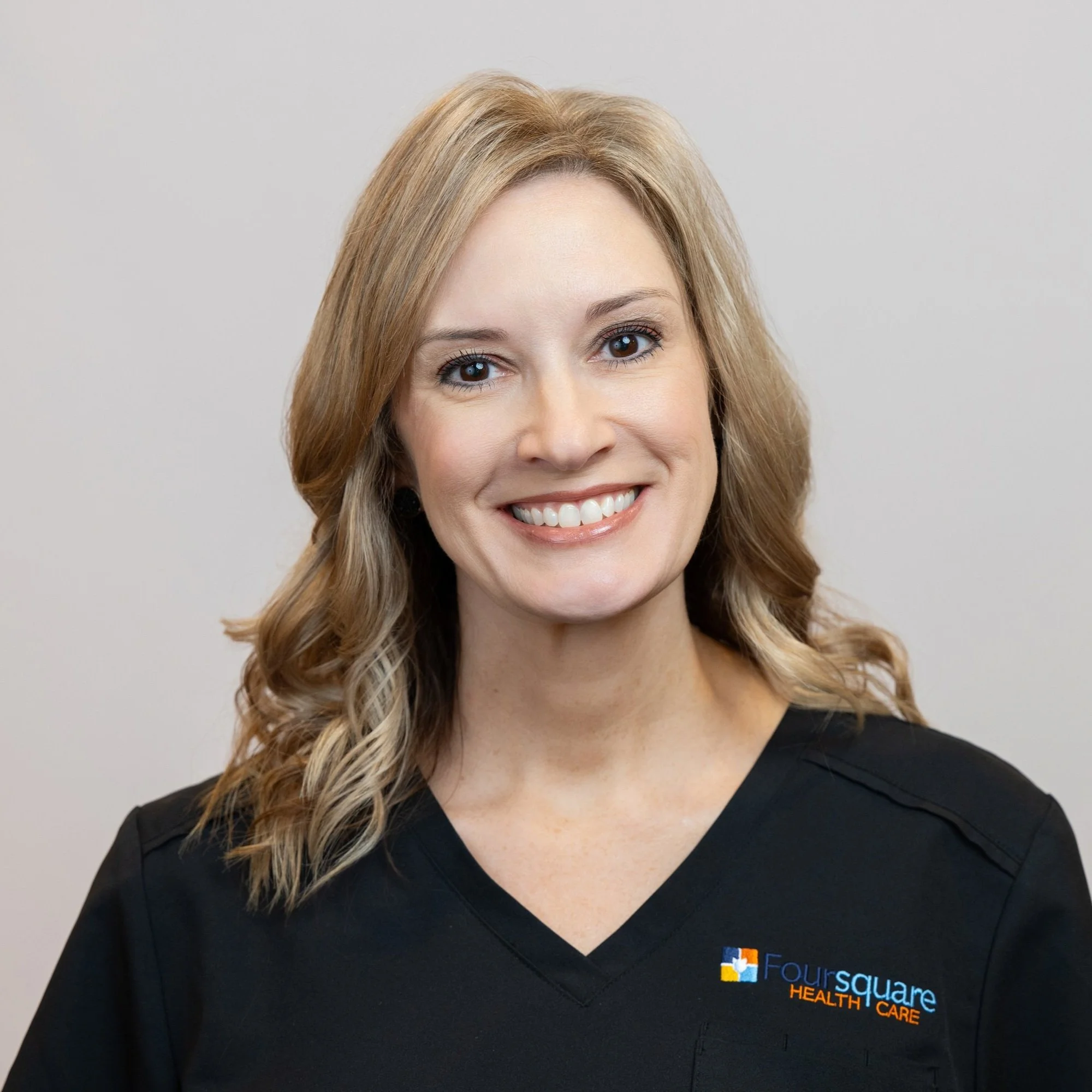 Margaret Shackelford wearing a black shirt with 'Four Square Health Care' logo on it.
