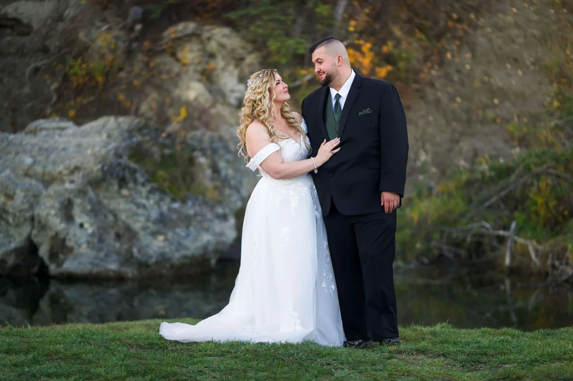 A mountain landscape with snow-capped peaks in the background and a modern building in the foreground, surrounded by rolling green hills.