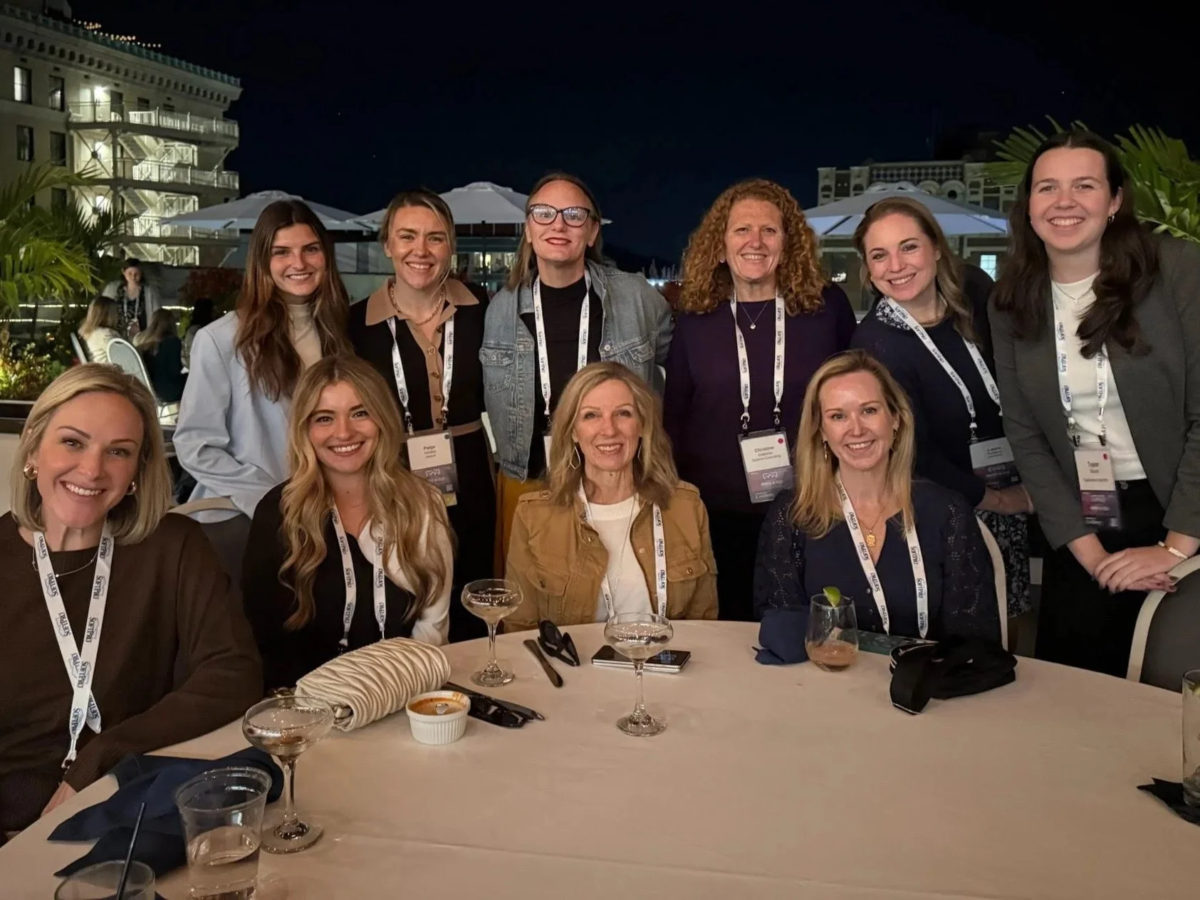 Photo of two rows of women sitting around a table smiling