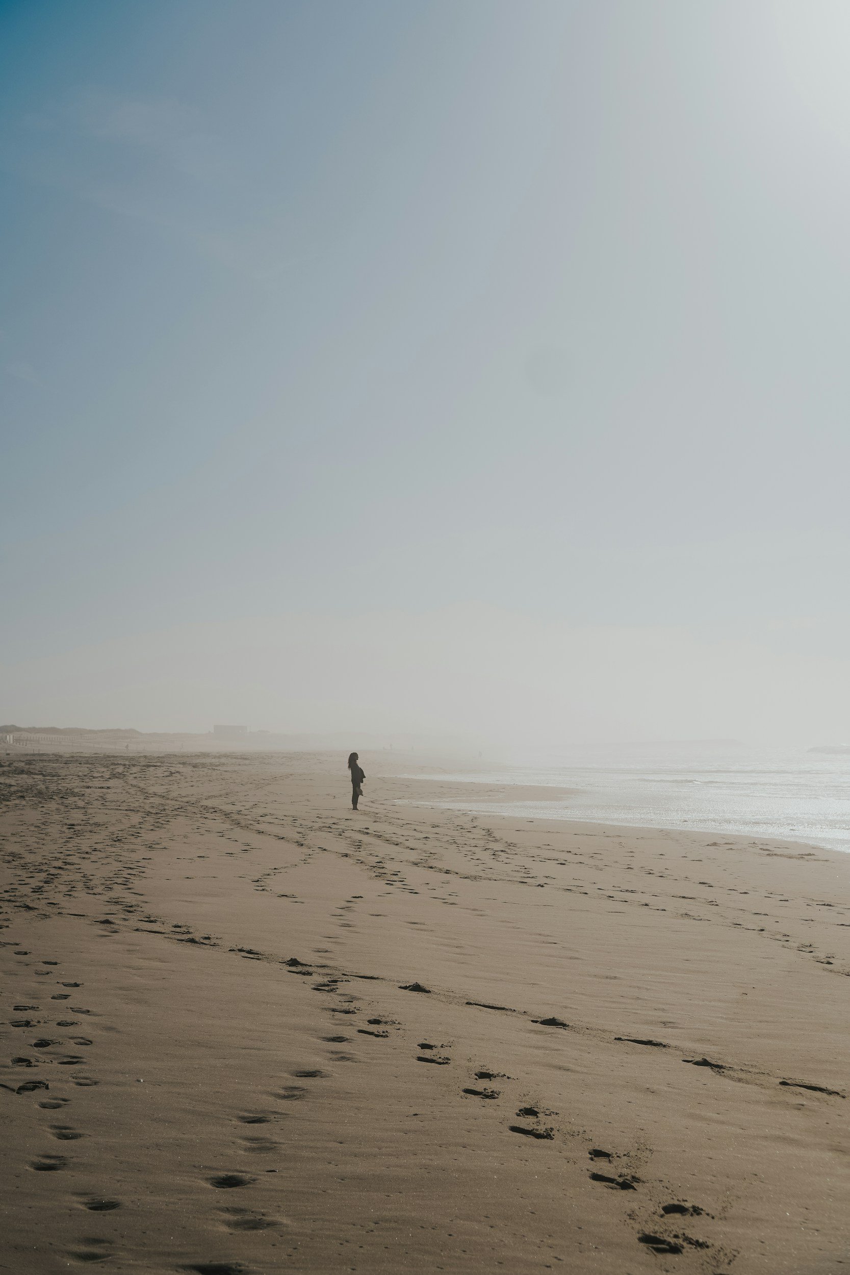Person walking along the beach near the ocean