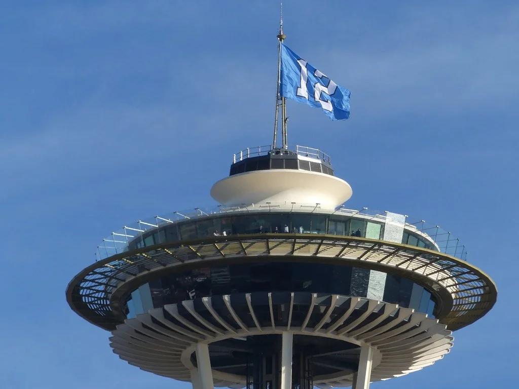The top of the Space Needle with a Seahawks "12" flag waving from the needle.