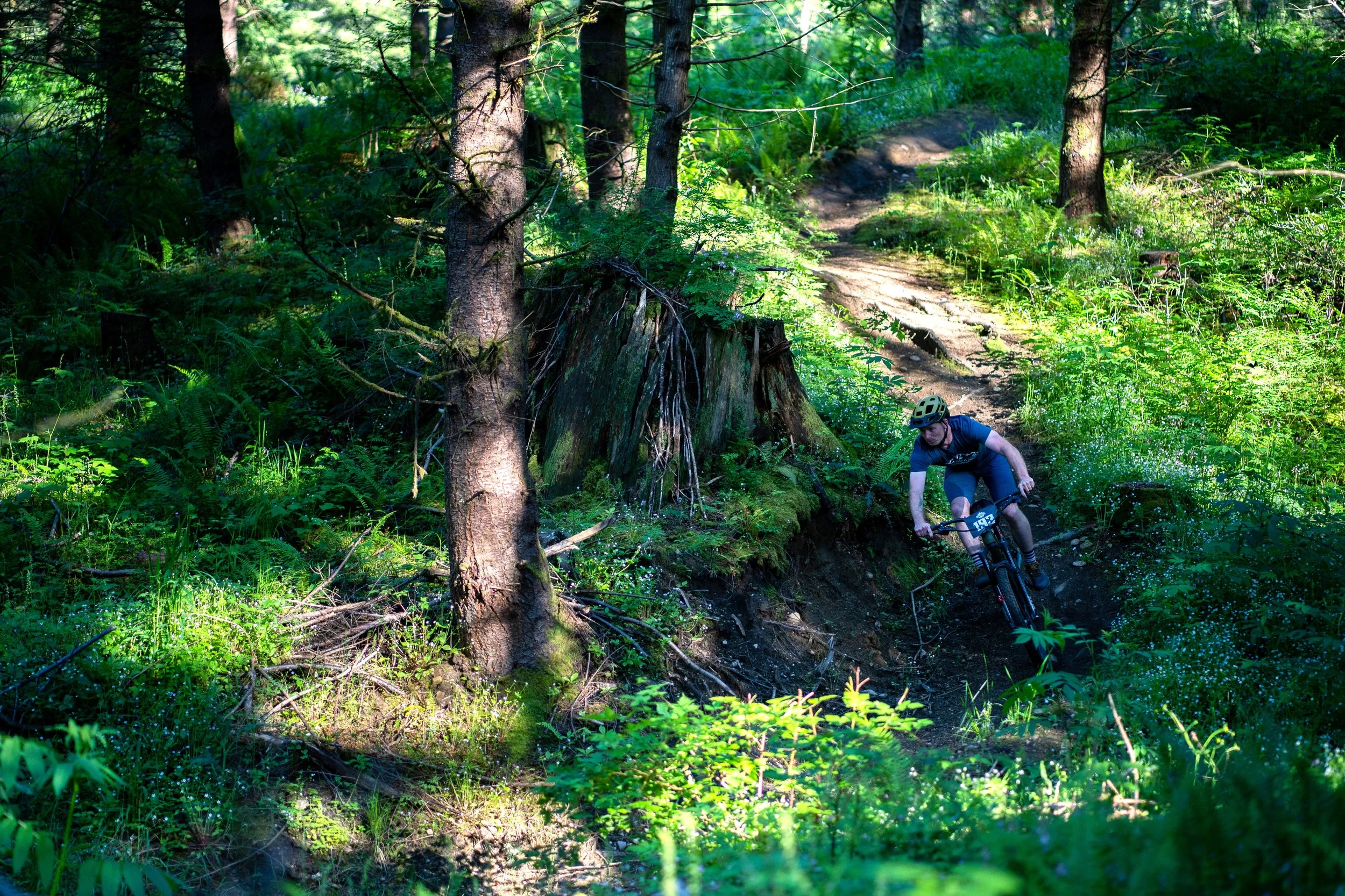 A person mountain biking on a dirt trail.
