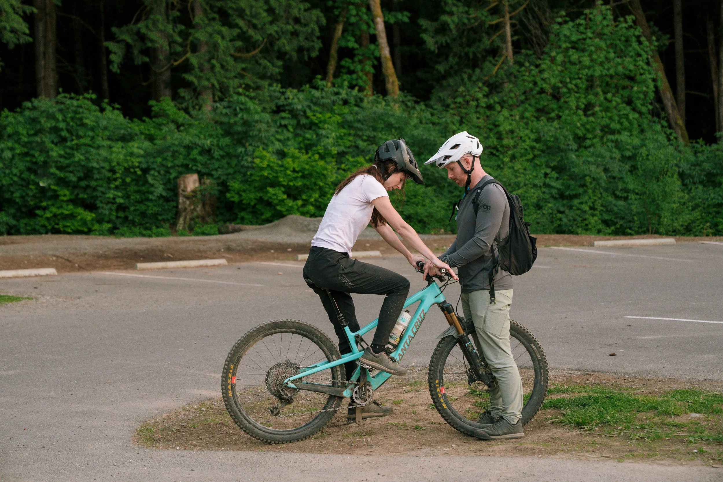 coach helping rider set up her bike