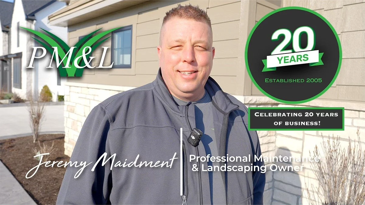 Portrait of Jeremy Maidment, a professional maintenance and landscaping owner, standing outdoors in front of a building, celebrating 20 years of business since 2005, with a logo featuring a green check mark and the text 'PM&L'