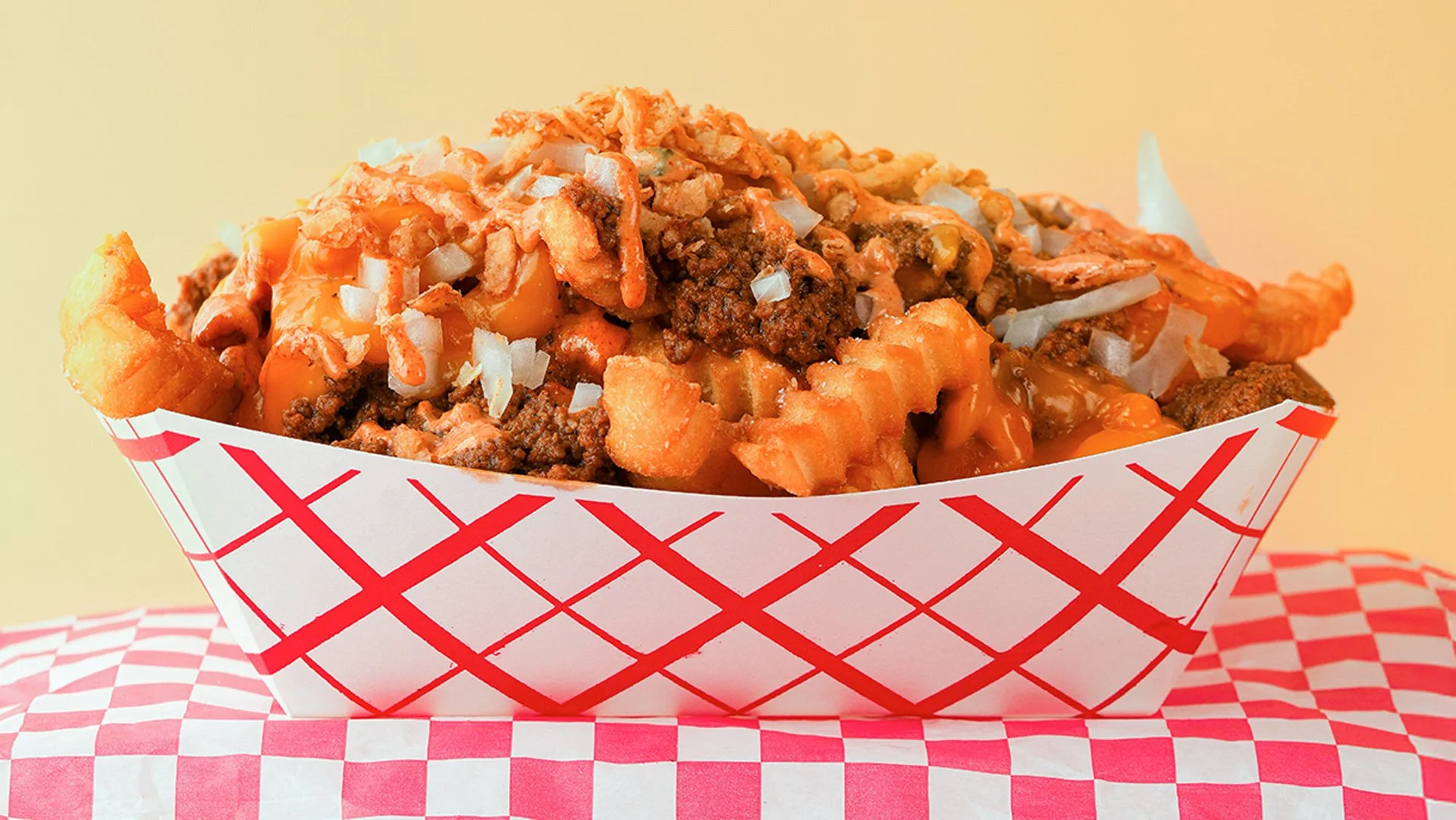 CHILI CHEESE loaded crinkle fries. Coney sauce, griddled sweet onion, and cheese sauce. Served from our food truck in Midcoast Maine and catering your next event.
