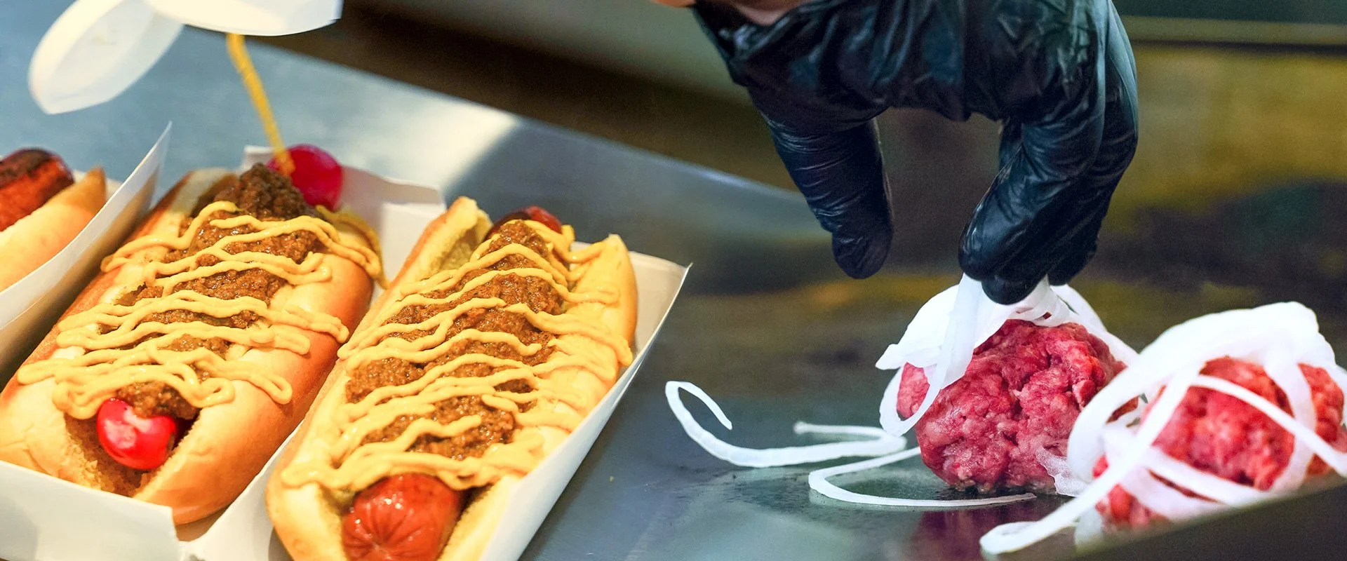 Our loaded Coney hot dogs topped with Raye's mustard, coney sauce, and diced sweet onion. Prepping our quarter pound smash patties with Pineland Farms ground beef and paper thin sweet onion.