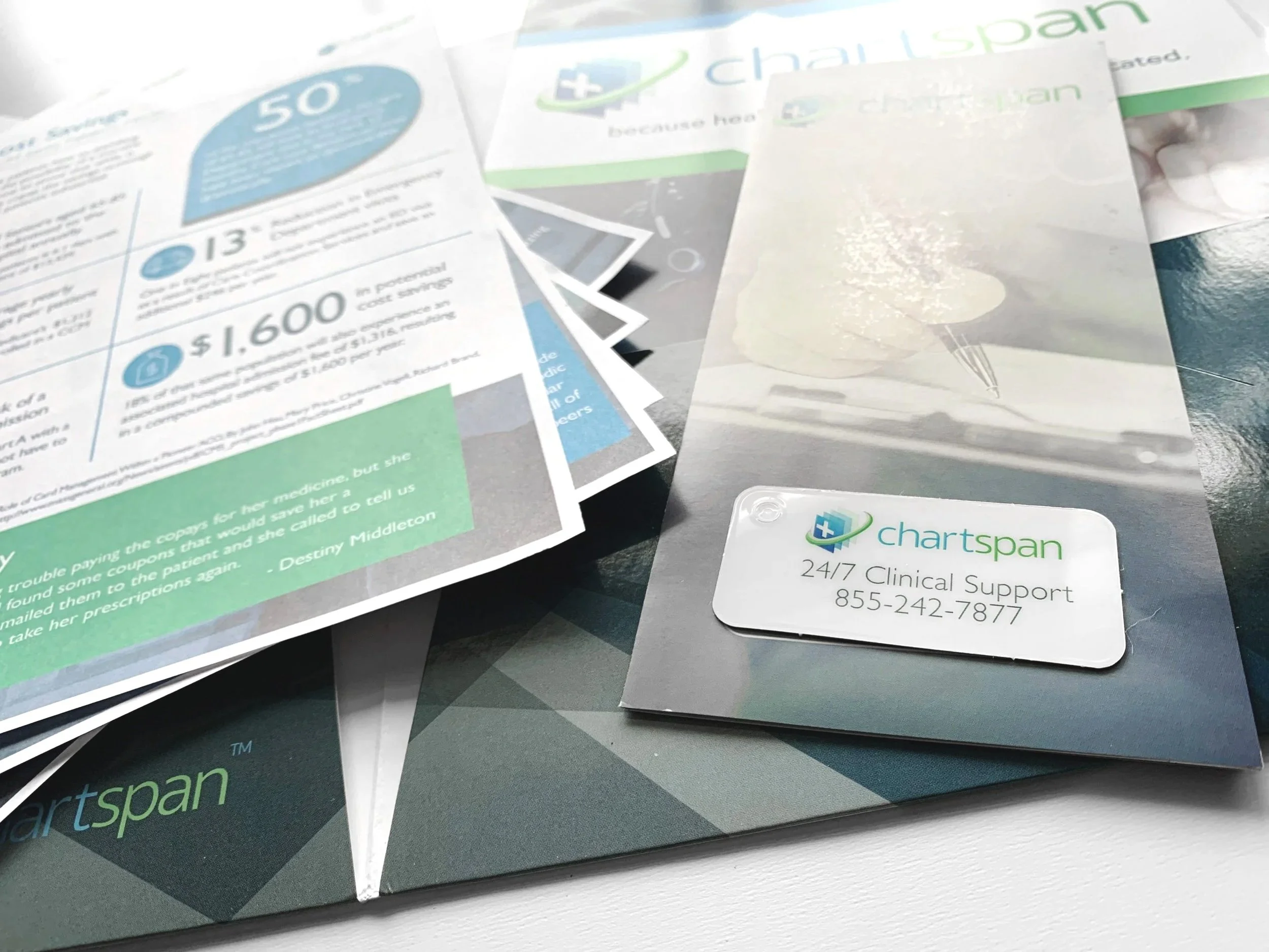 Close-up of printed promotional materials and business cards on a table, with visible text and graphics promoting ChartSpan, a healthcare support company.