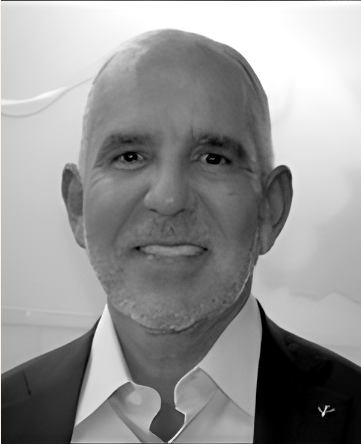 Black and white photo of a smiling man in a suit jacket and collared shirt