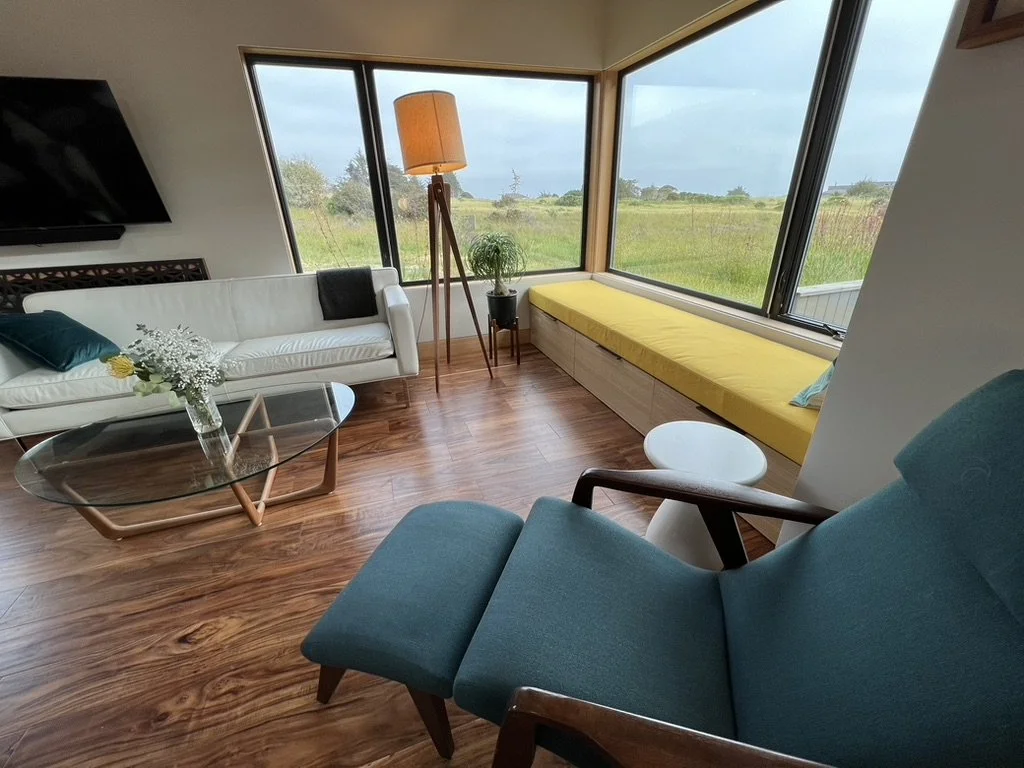 Full-scope interior design including custom kitchen, architectural detailing, finish selections, and furnishing composition. Vaulted ceilings and expansive glazing create openness, balanced by white oak doors, inset baseboards, hemlock trim, and waln