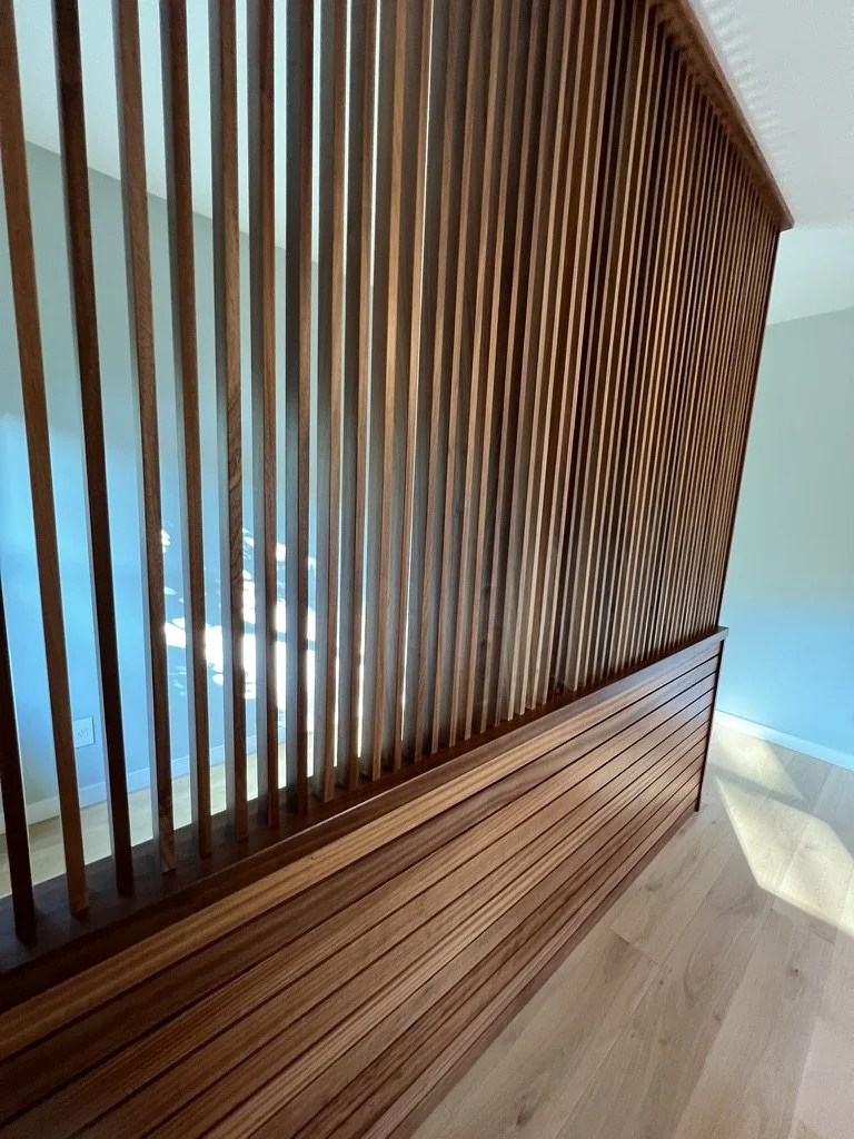 Slatted Divider introduces a custom sapele structure designed to modulate the transition between bedroom and office, softening the shift in energy while maintaining visual connection and light flow. Developed in collaboration with a local woodworker,