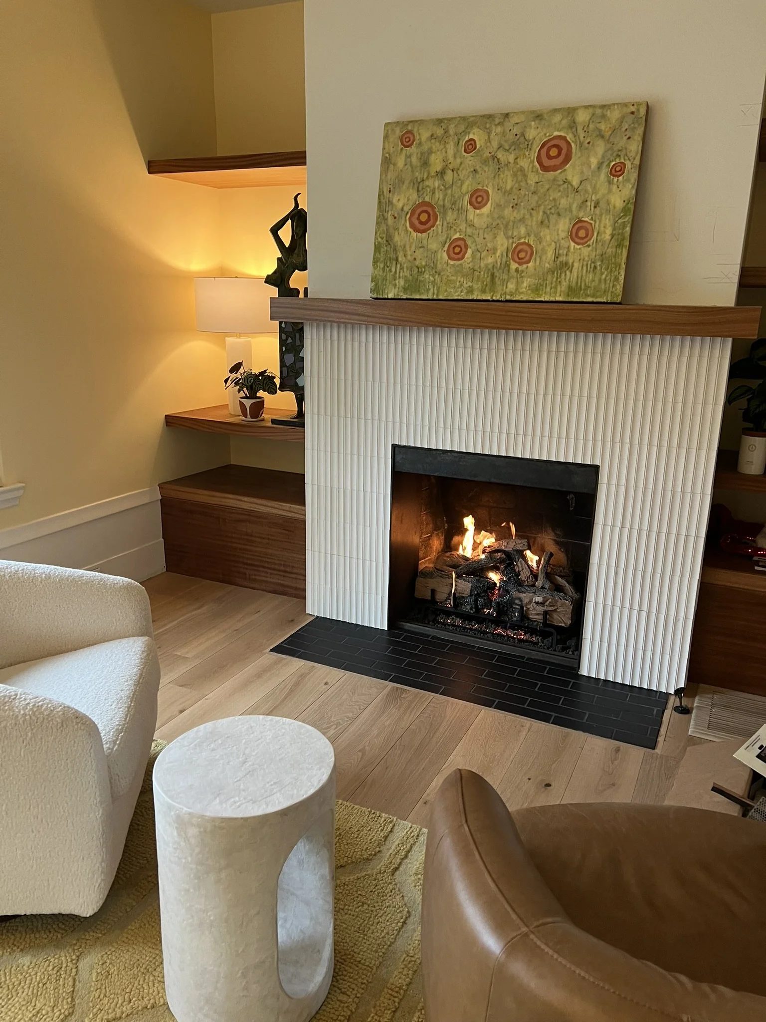 living room with fireplace and built-in shelving featuring balanced composition and warm materials