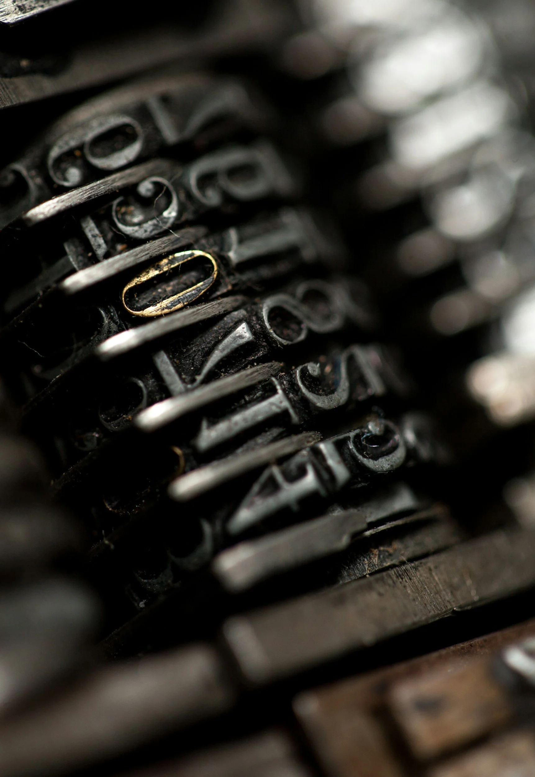 Close-up of vintage typewriter keys showing black keys with white and gold letters.