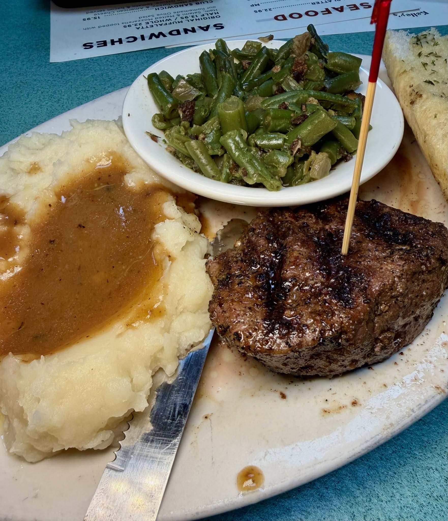 Steak plate with brown gravy, mashed potatoes and green beans at Kelley's Village Inn