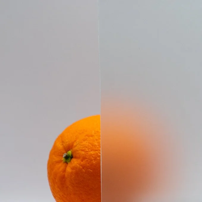 Close-up of an orange fruit with a mirror creating a reflection effect