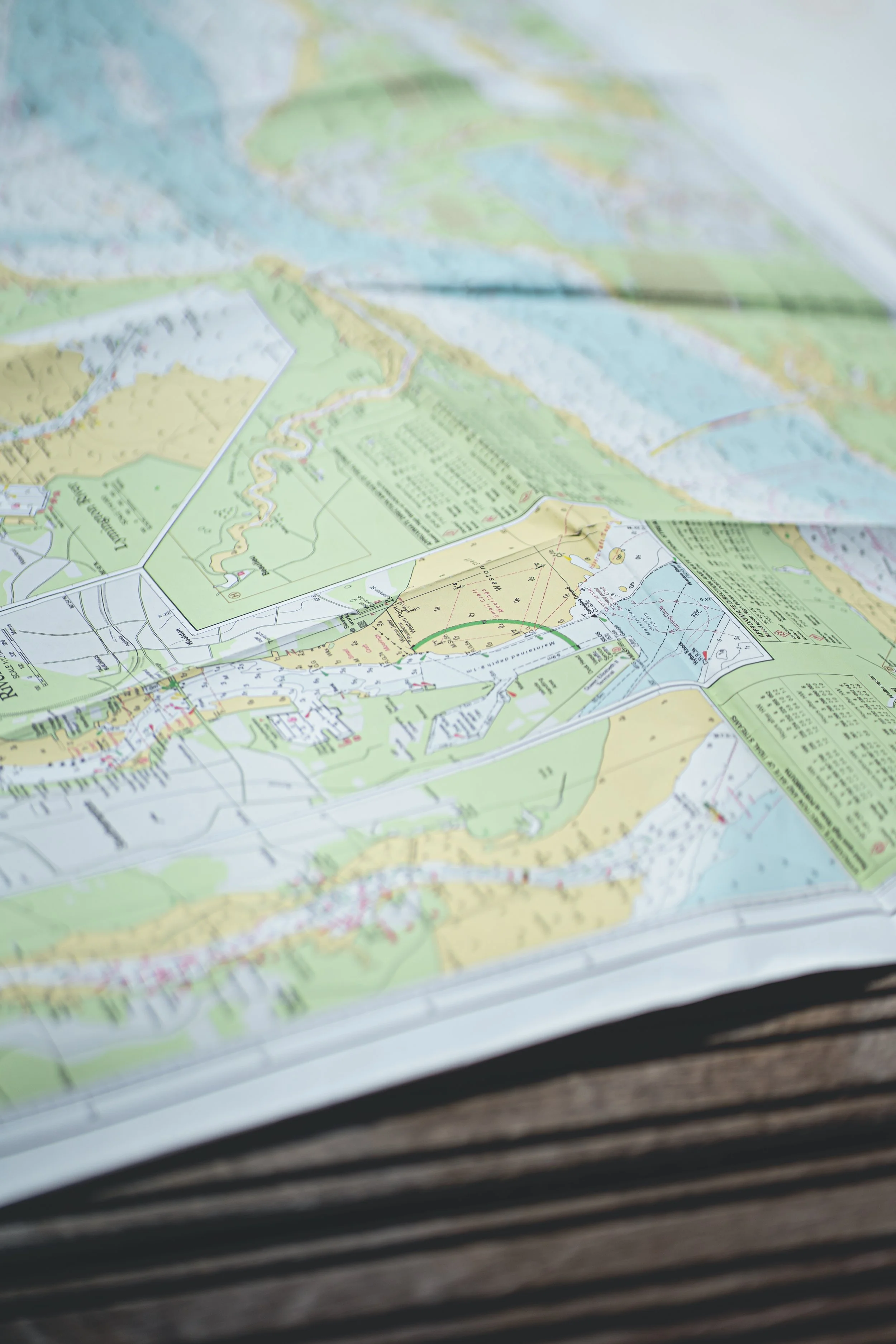 A folded map with colorful markings, laid open on a wooden surface.