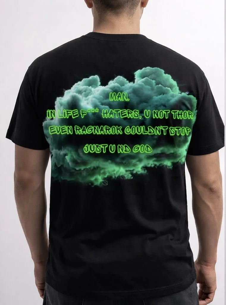 Back of a person wearing a black T-shirt with a green and black cloud design and text that reads 'Man. In life f*** haters, U not tho even Ragnarok couldnt stop just u nd God'.