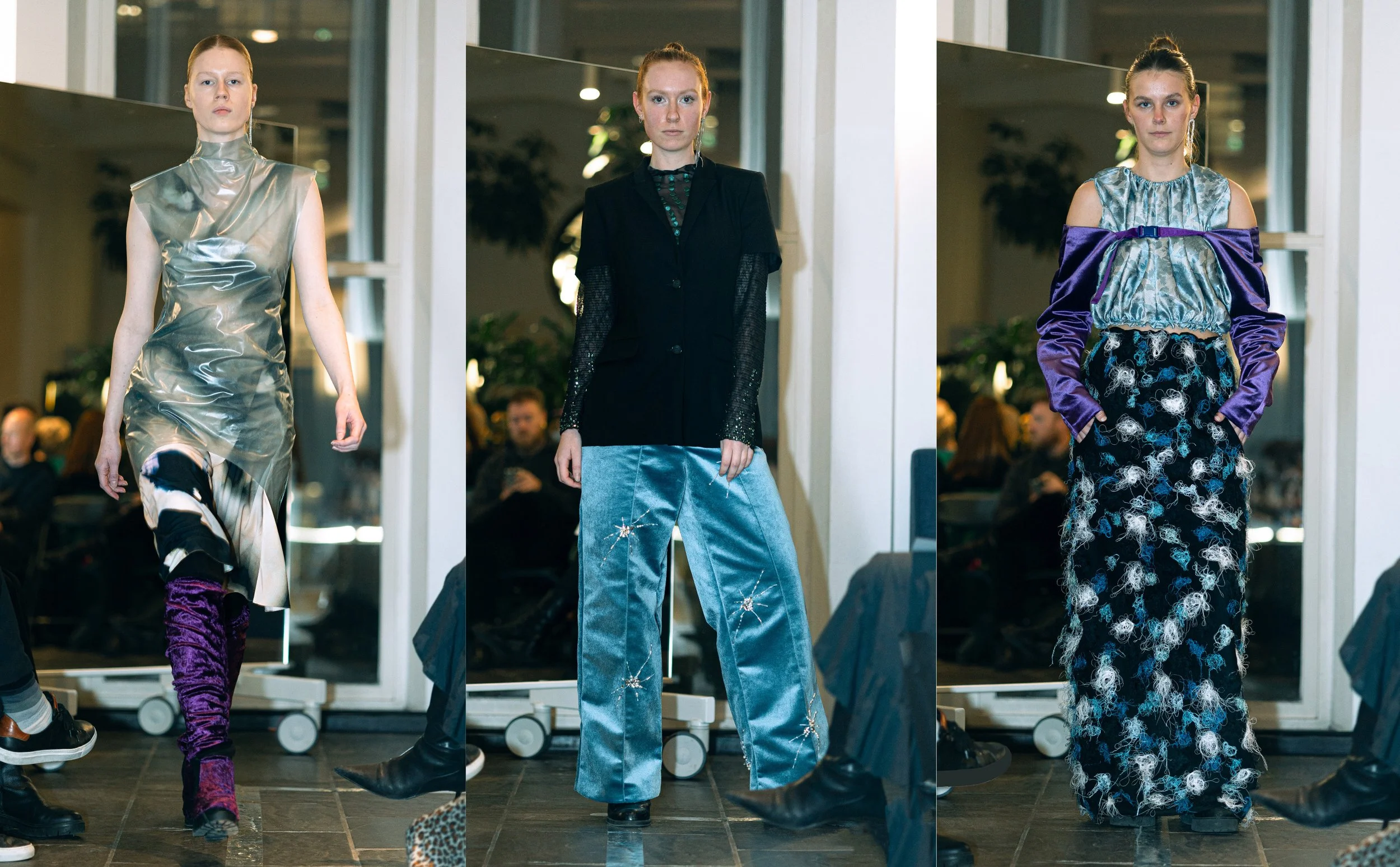 Three models showcasing fashion designs on a runway, with audience members visible in the background.