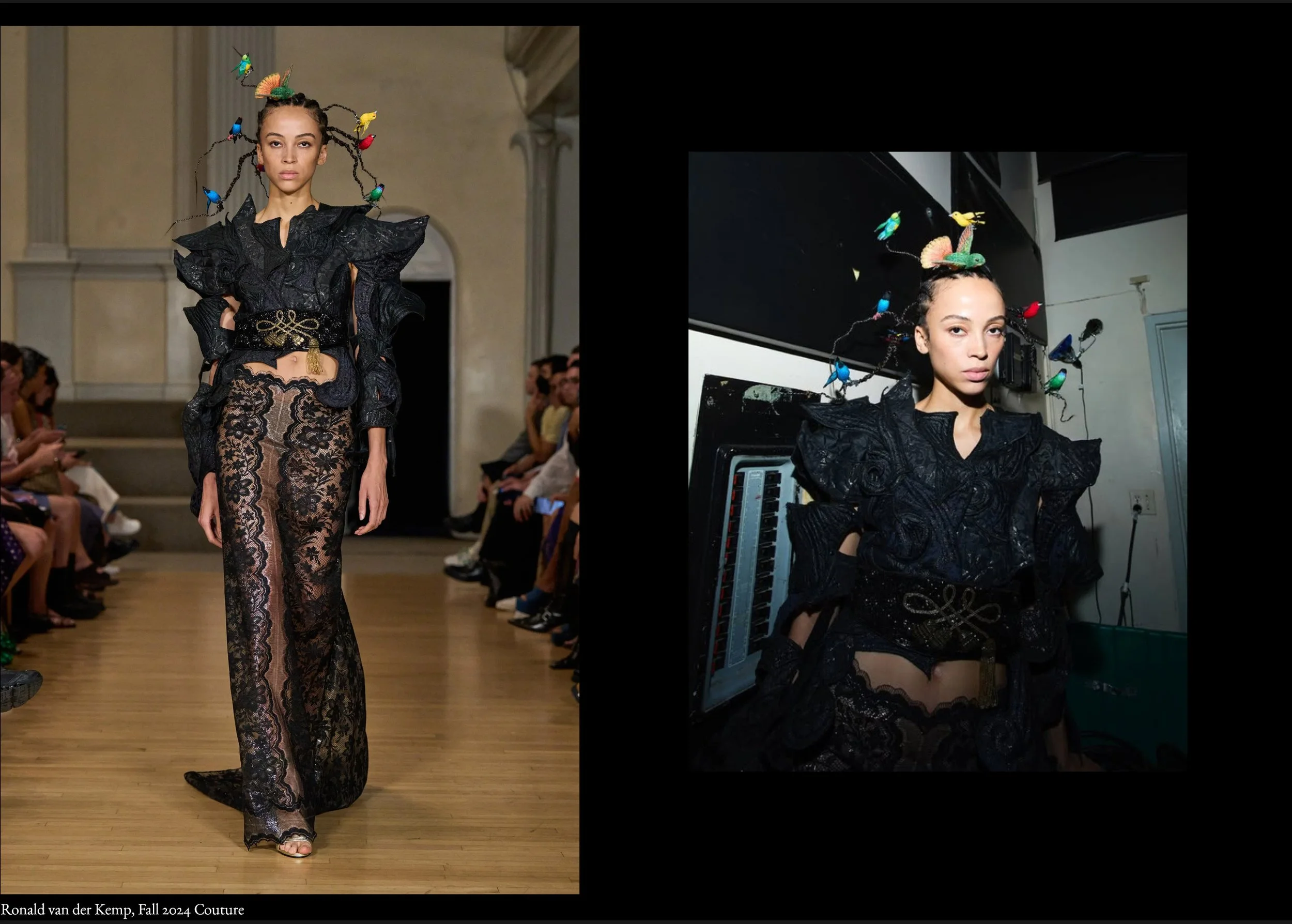 Fashion model walking down runway in black lace ensemble with exaggerated shoulders and snake-shaped belt, ornate headpiece with colorful birds and insects, setting appears to be a fashion show runway.