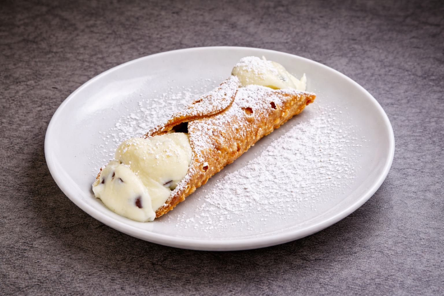 A slice of apple pie with a scoop of vanilla ice cream on a white plate, dusted with powdered sugar.