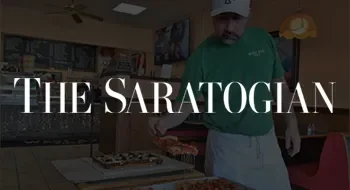 Cover image of a book titled 'The Saratogian' with a man in a green shirt preparing food in a kitchen.