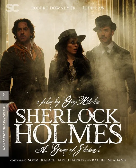 Promotional poster for the film "Sherlock Holmes: A Game of Shadows" featuring three characters in period costumes, fog, and vintage background, with text about the film and cast.