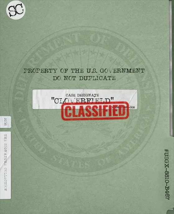 A U.S. government classified document with a green cover, indicating "Property of the U.S. Government, Do Not Duplicate," and a white label with the case designation "Cloverfield," stamped with a red "Classified" label.