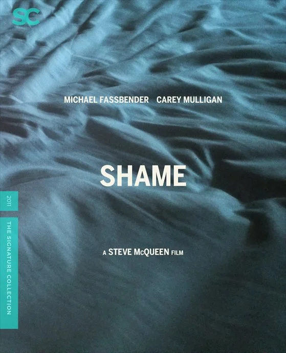Cover of the film 'Shame' directed by Steve McQueen, featuring the names Michael Fassbender and Carey Mulligan, with a background of wrinkled fabric in shades of blue.