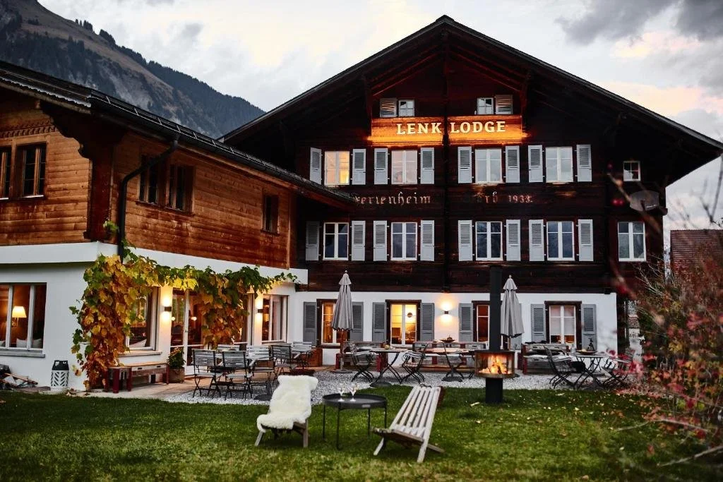 Lenk Lodge hotel from the outside at dusk with soft lighting.