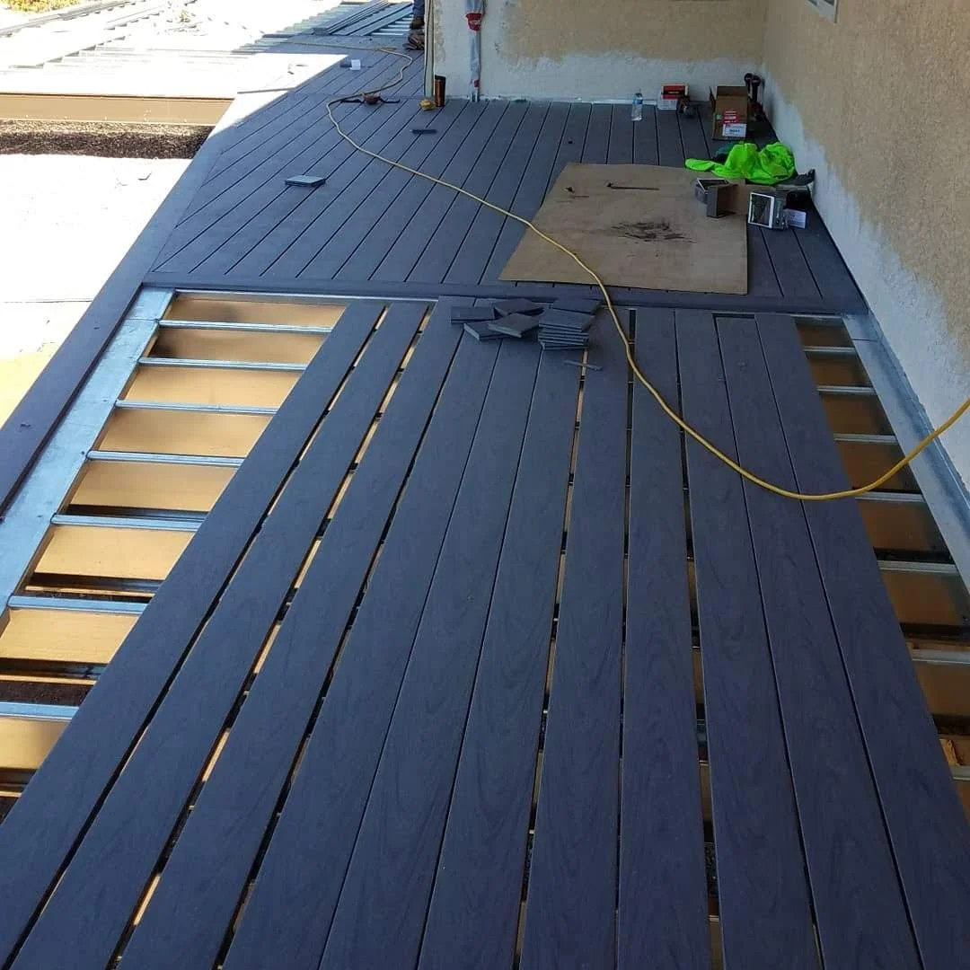 Under construction on a building with new Composite decking, tools, and building materials scattered around.