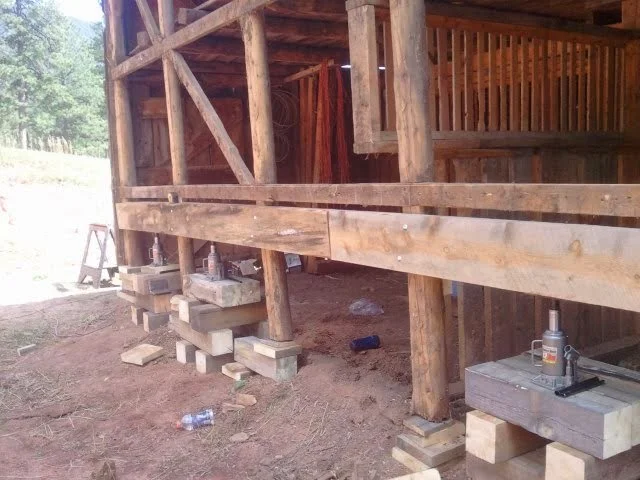 Barn repair and renovation , and woodworking tools and debris on the ground.