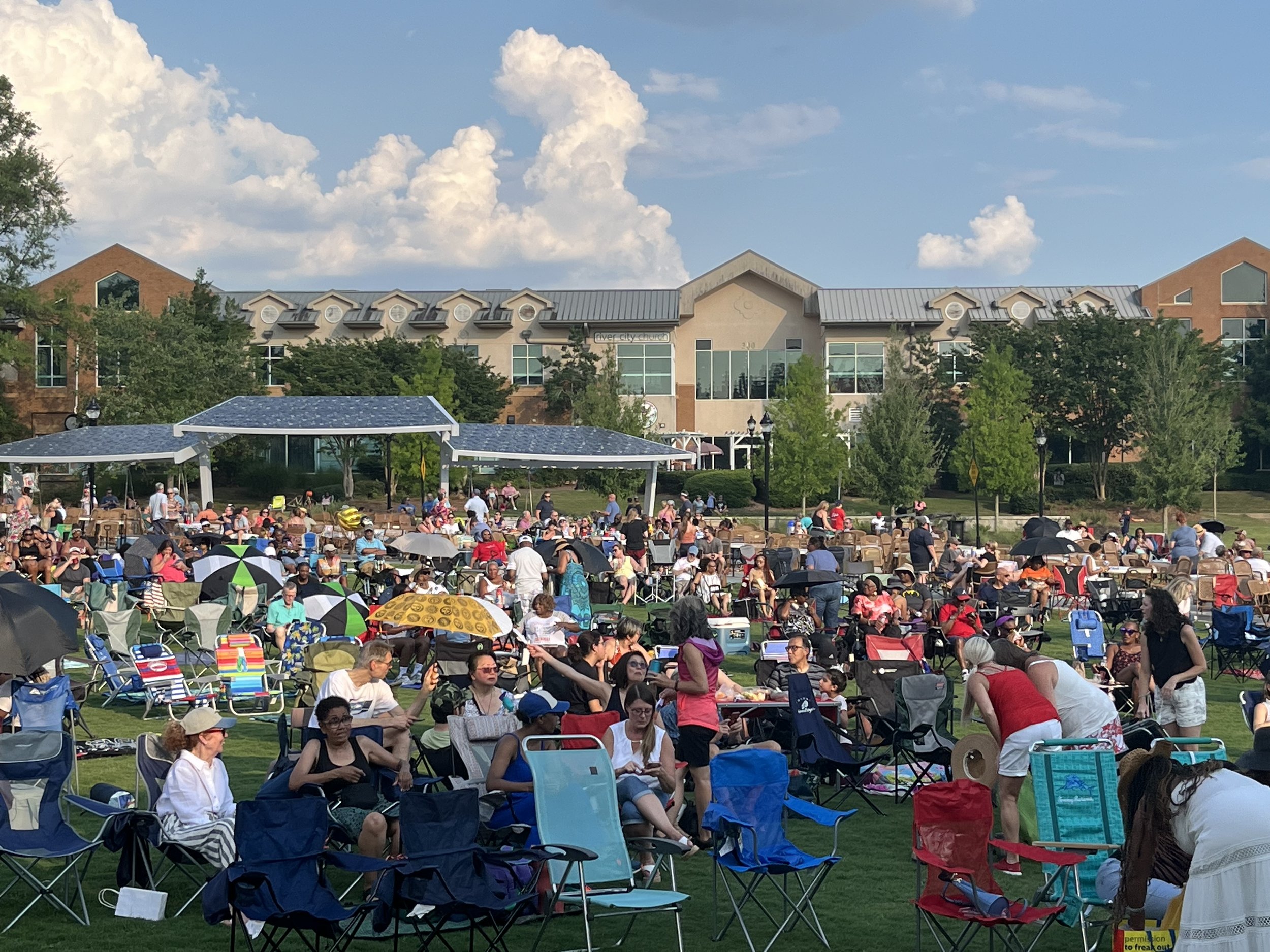 people in lawn chairs sitting in the Village Green for an event
