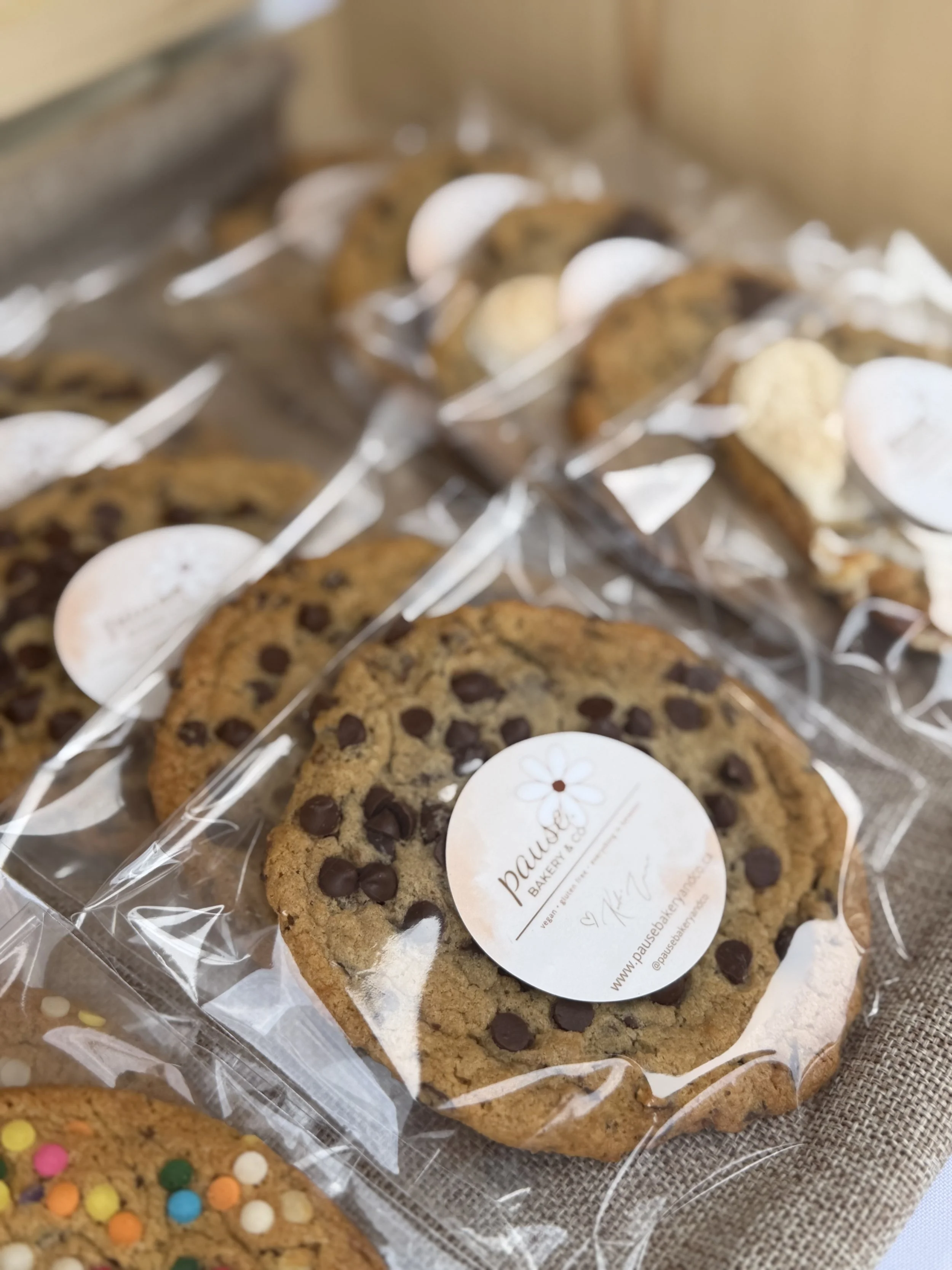 Close-up of a large chocolate chip s'mores cookie on a wooden surface.