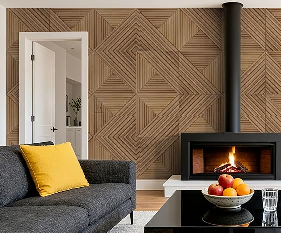 Living room with geometric wood-paneled accent wall, black fireplace with fire, black sofa with yellow pillow, white door, white side table with a bowl of apples, and a glass of water.