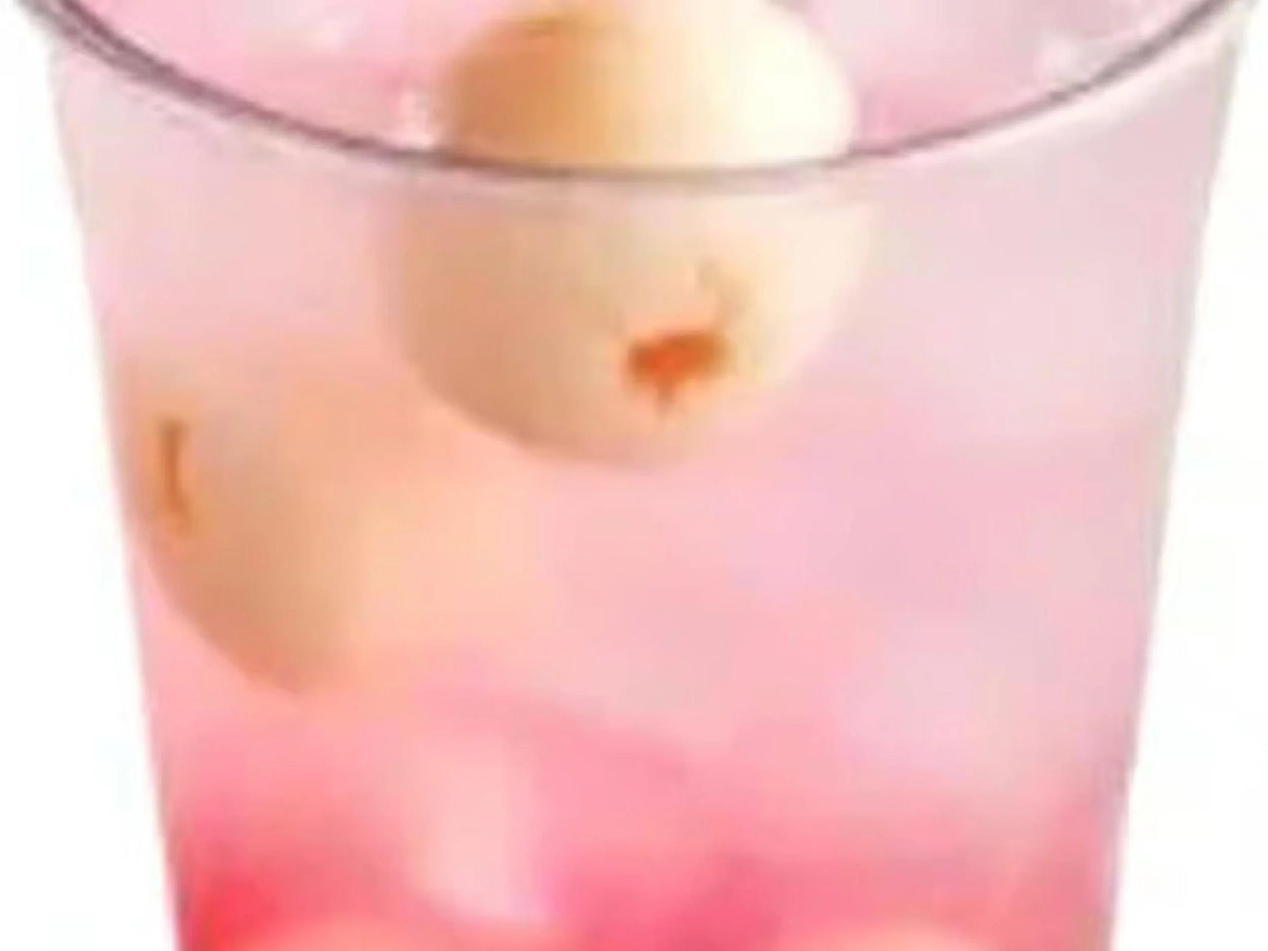 Close-up of a pink cocktail or beverage with ice and a cherry garnish in a glass.