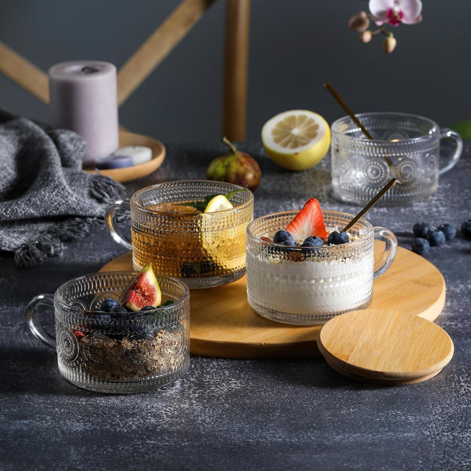 Glass drinkware with fruit-garnished beverages styled on a wood serving tray for home entertaining.
