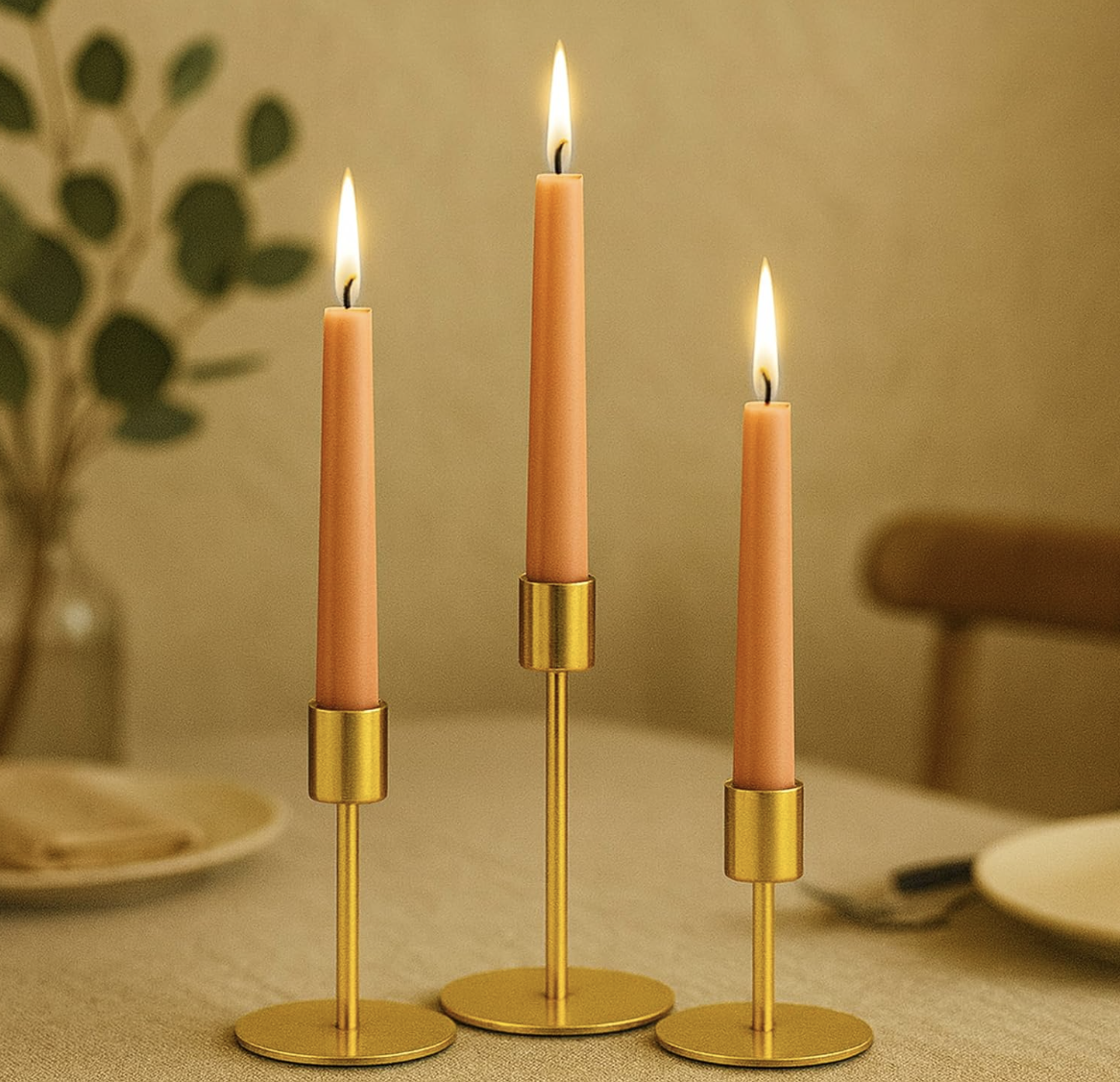 Pink taper candles in gold holders styled on a dining table for warm, elegant home entertaining.
