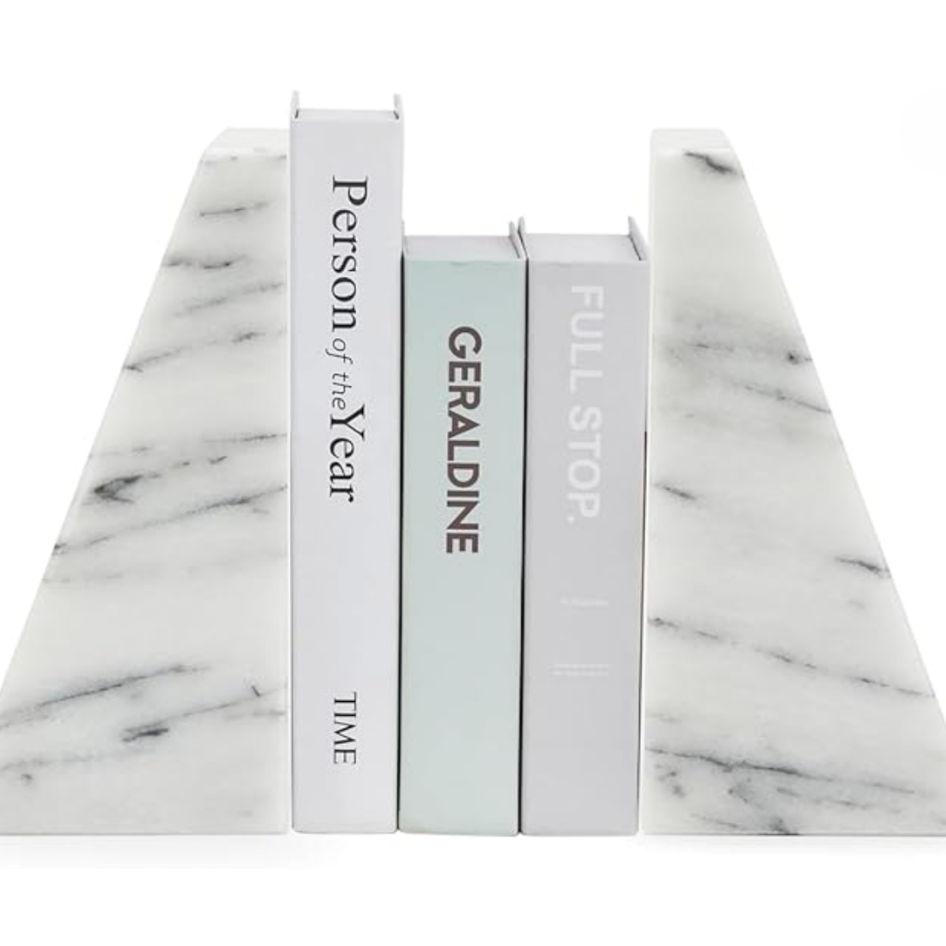 Neutral coffee table books styled on a white marble surface for curated home decor.