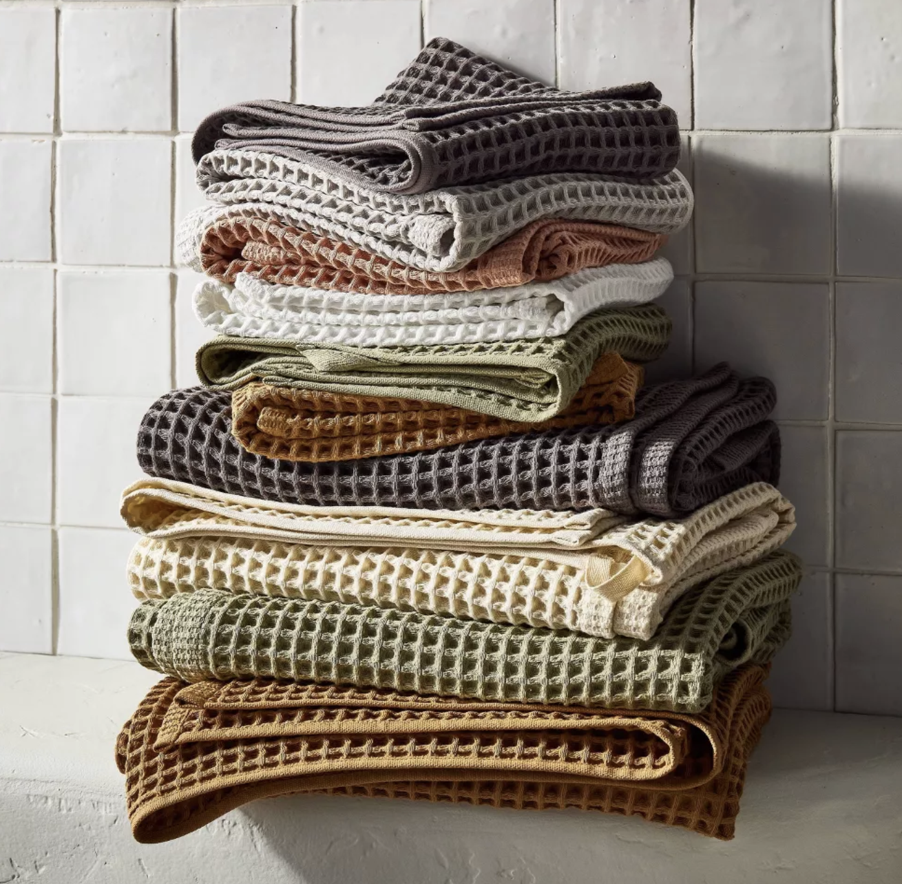 Layered bath towels in coordinating colors and textures for bathroom styling.