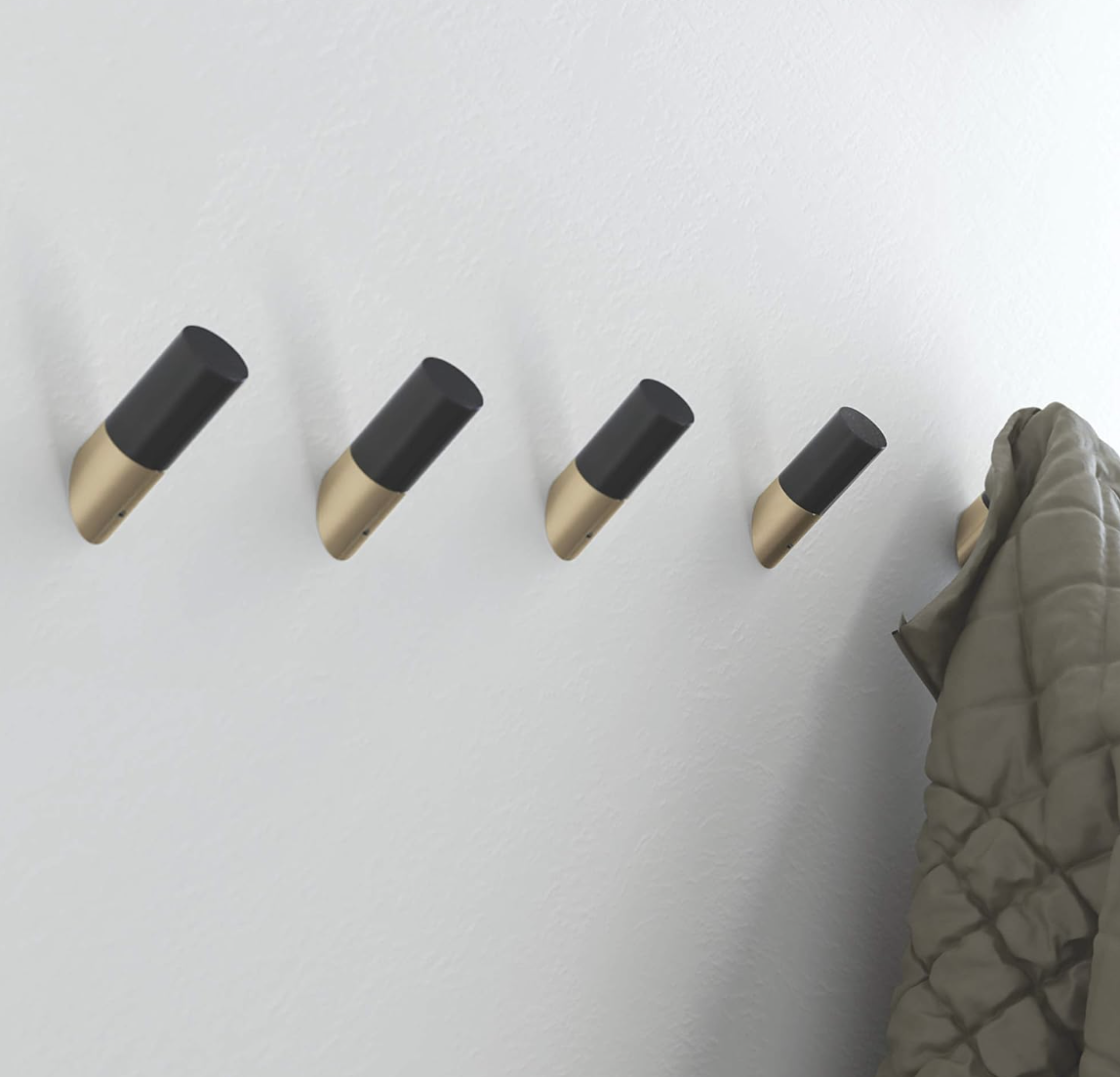 Minimalist wall-mounted coat hooks with hanging outerwear for entryway organization.