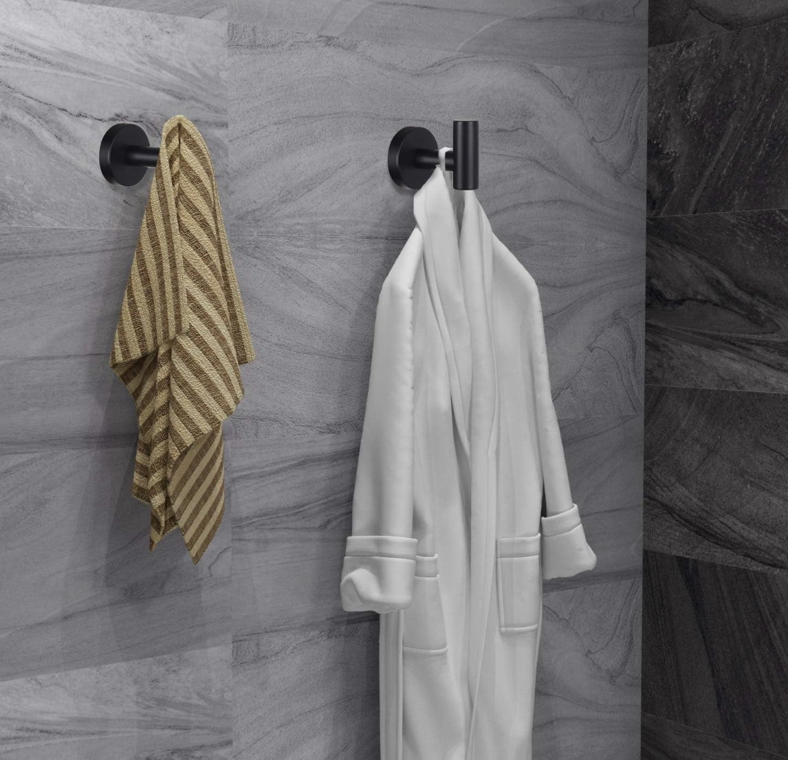 Black bathroom wall hooks with striped towel and white bathrobe against gray tile.