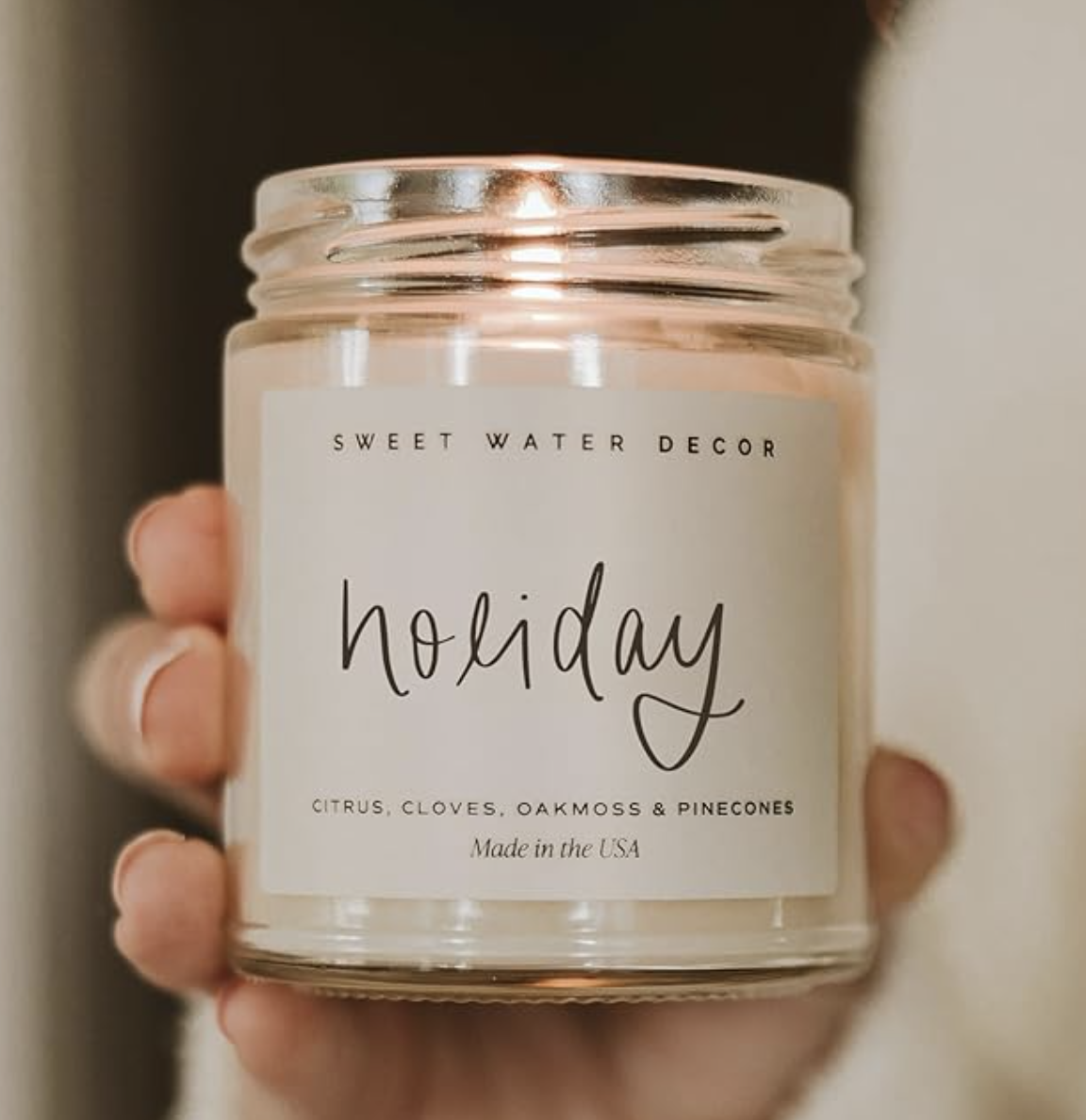 Sweet Water Decor Holiday candle with citrus, clove, oakmoss and pinecone fragrance notes.