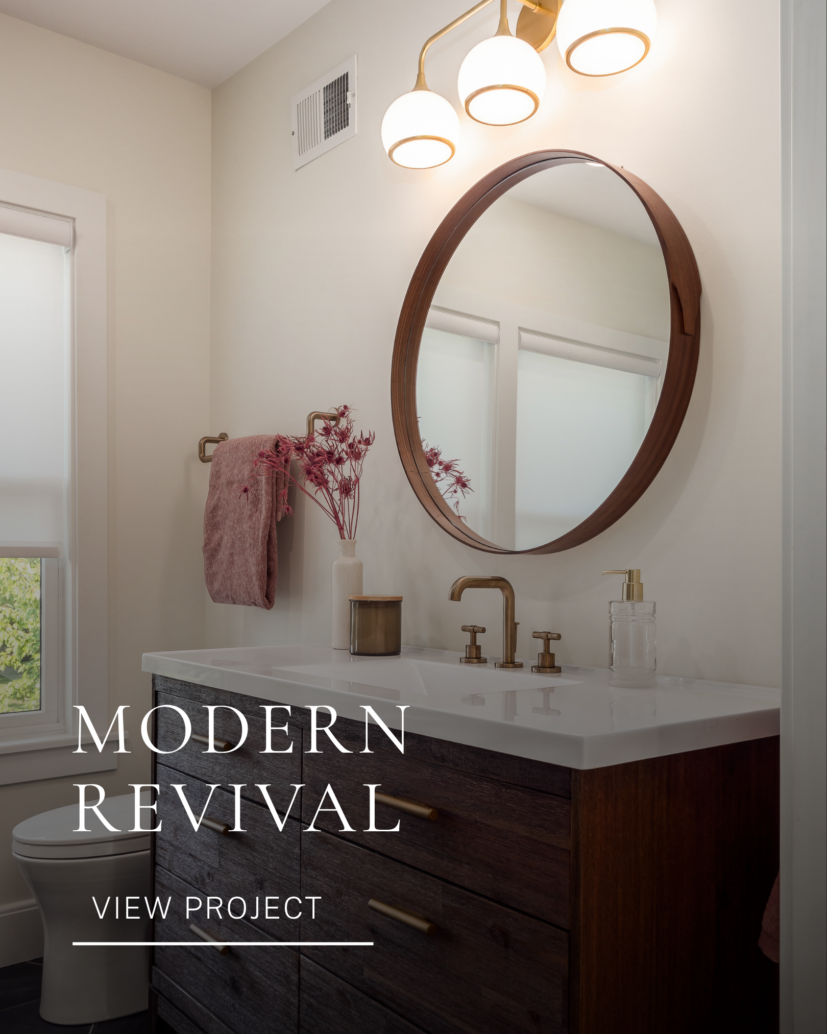 Residential bathroom design featuring a dark wood vanity, round mirror and soft decorative details.